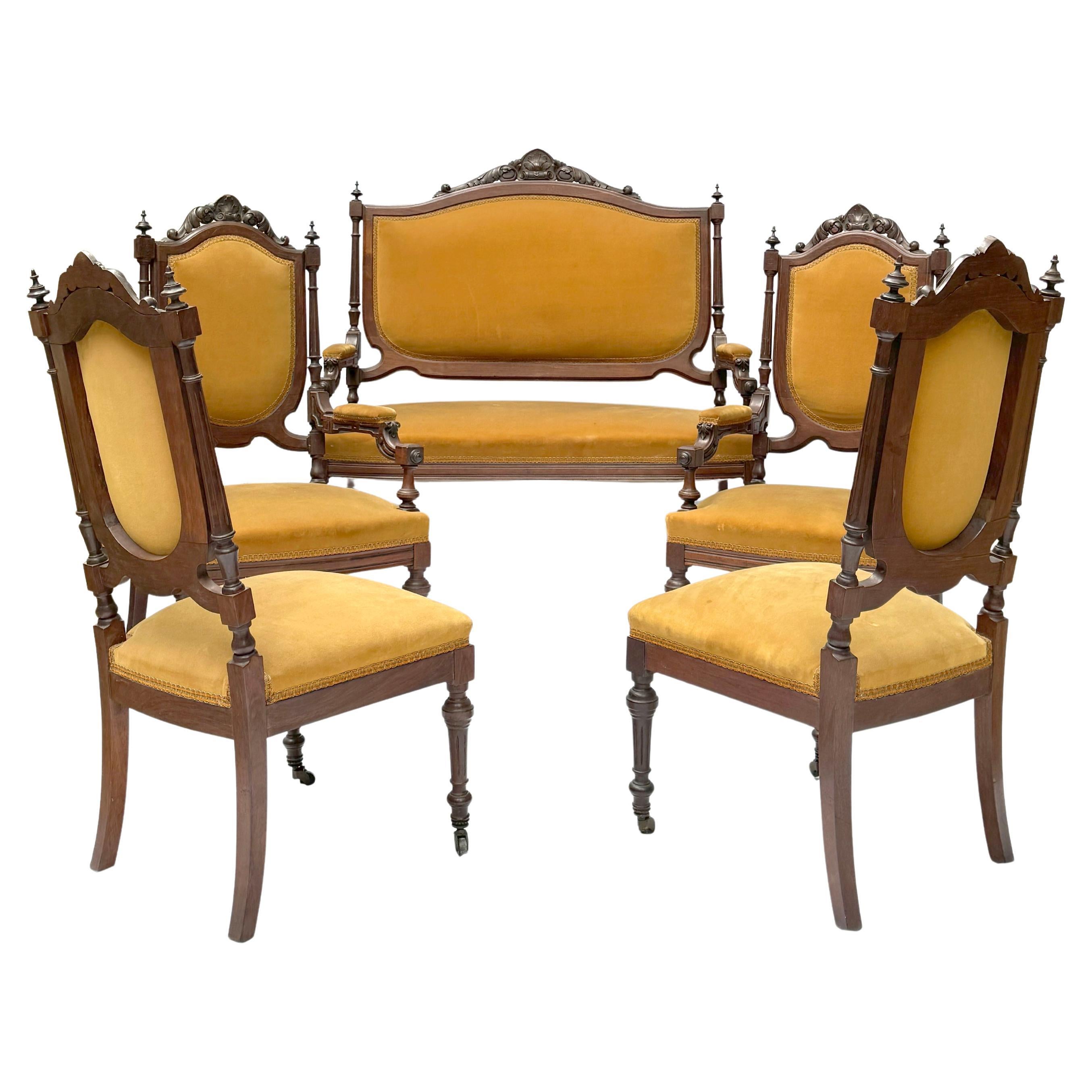 Ce remarquable ensemble de salon à cinq pièces du XIXe siècle est un exemple stupéfiant de l'artisanat et de l'élégance de l'ère victorienne. Composé d'un grand canapé et de quatre chaises exquises, dont deux fauteuils et deux chaises d'appoint, cet