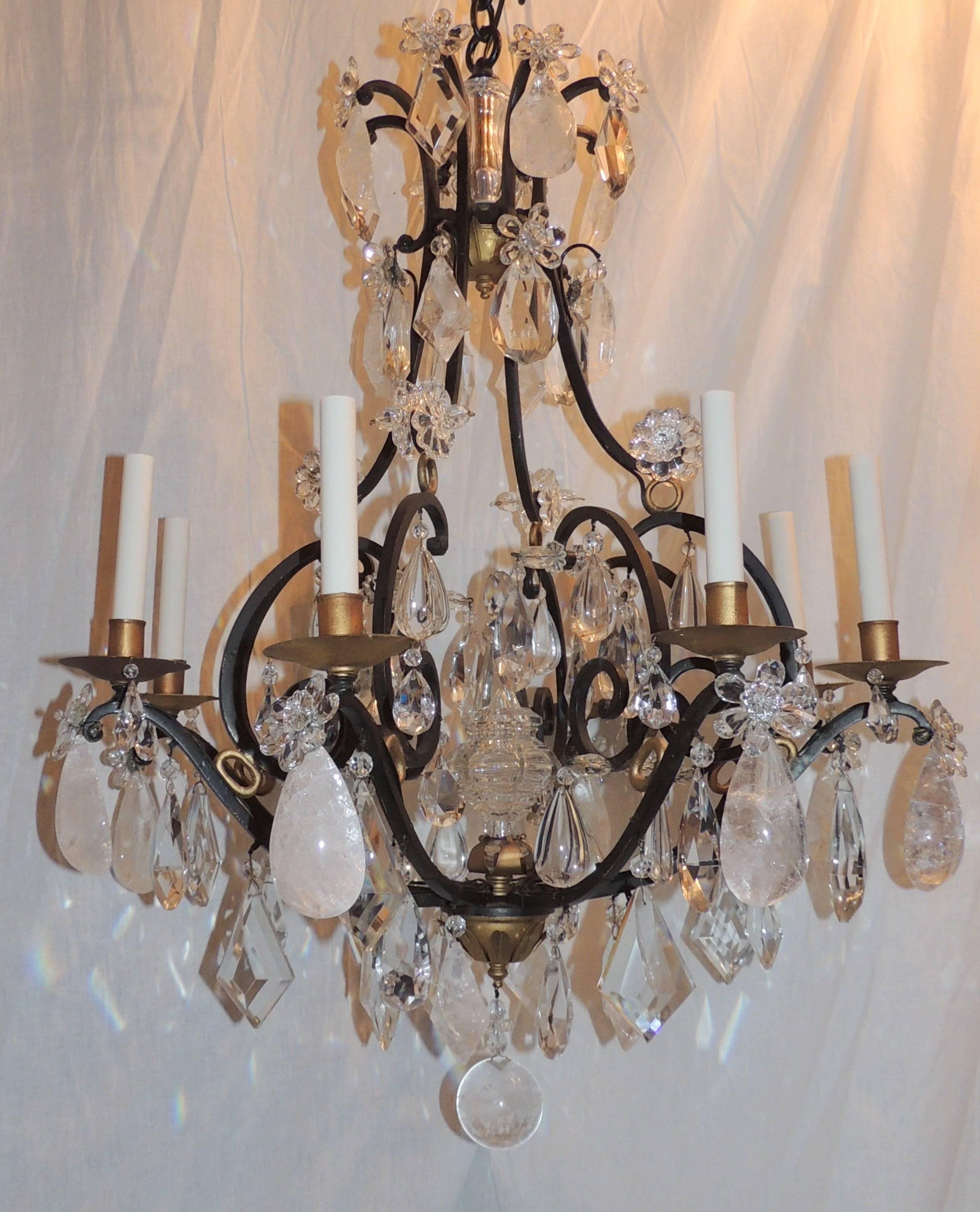 Beautiful scrolled wrought iron eight-arm chandelier with gilt candle cups and accents. Beautiful rock and prism crystal are throughout this wonderful chandelier.

Measures: 36