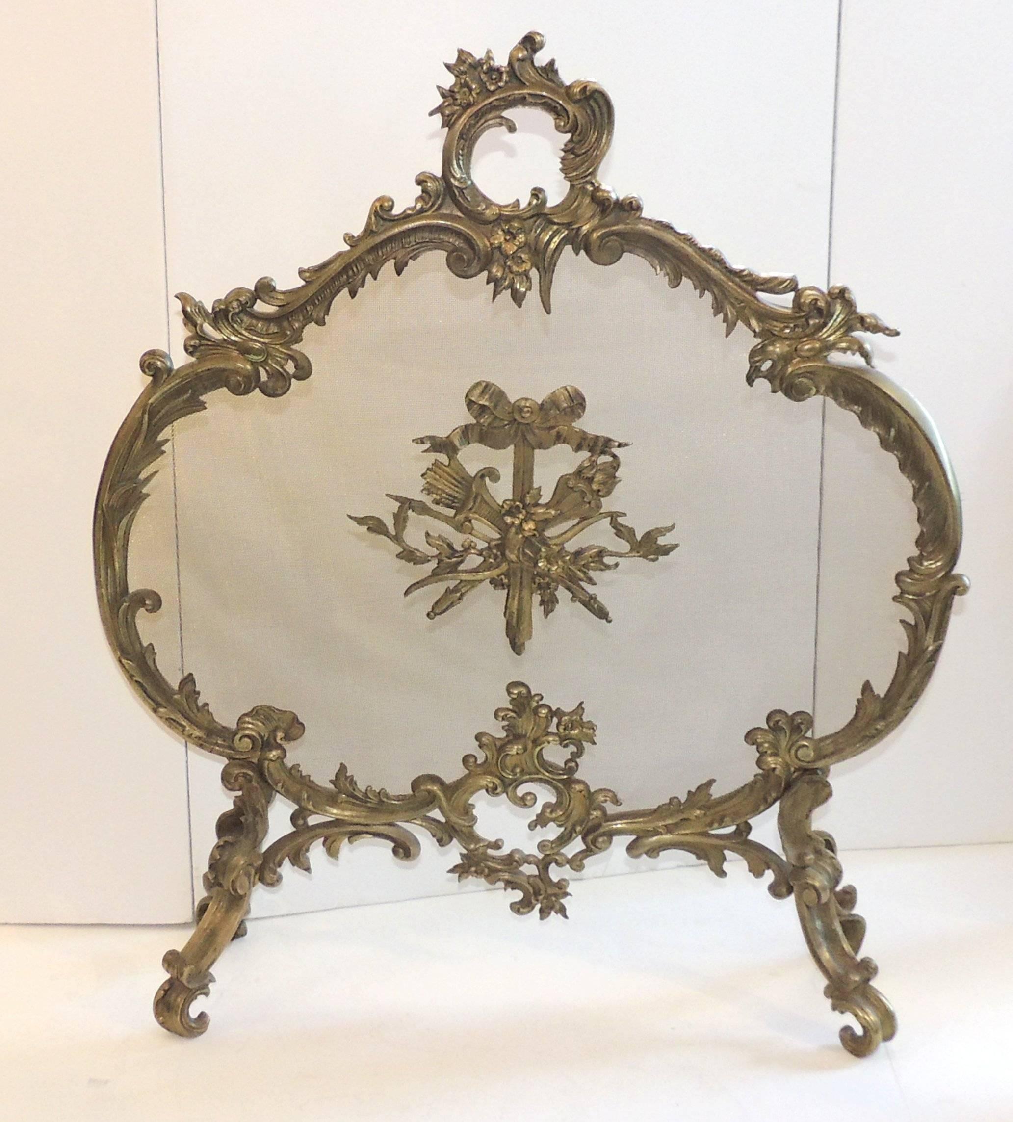 Elegant French bronze fire screen with filigree and bows surrounding the screen and with scroll and filigree feet.

Measures: 26