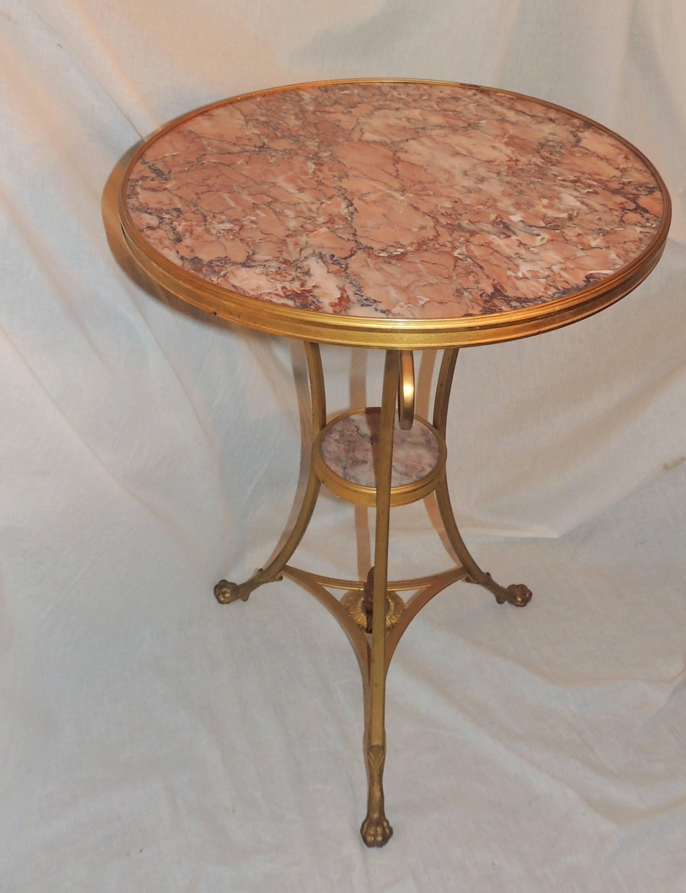 
Wonderful French etched bronze ormolu and rouge marble-top gueridon table with 6" rouge marble center shelf. Scroll arms accent the sides of this table with lovely claw feet.

Measures: 19" W x 28" H with 6" center shelf.