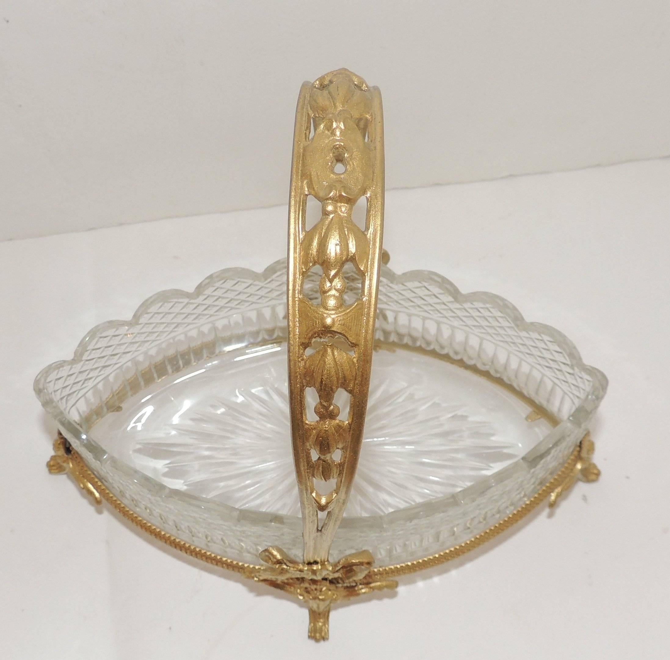 This beautiful diamond shaped crystal insert has a fluted bottom and cut crystal
border which is scalloped. The doré bronze basket is decorated with figural heads, fine etched details floral decorated handle and finished with gilt bows.

Insert: