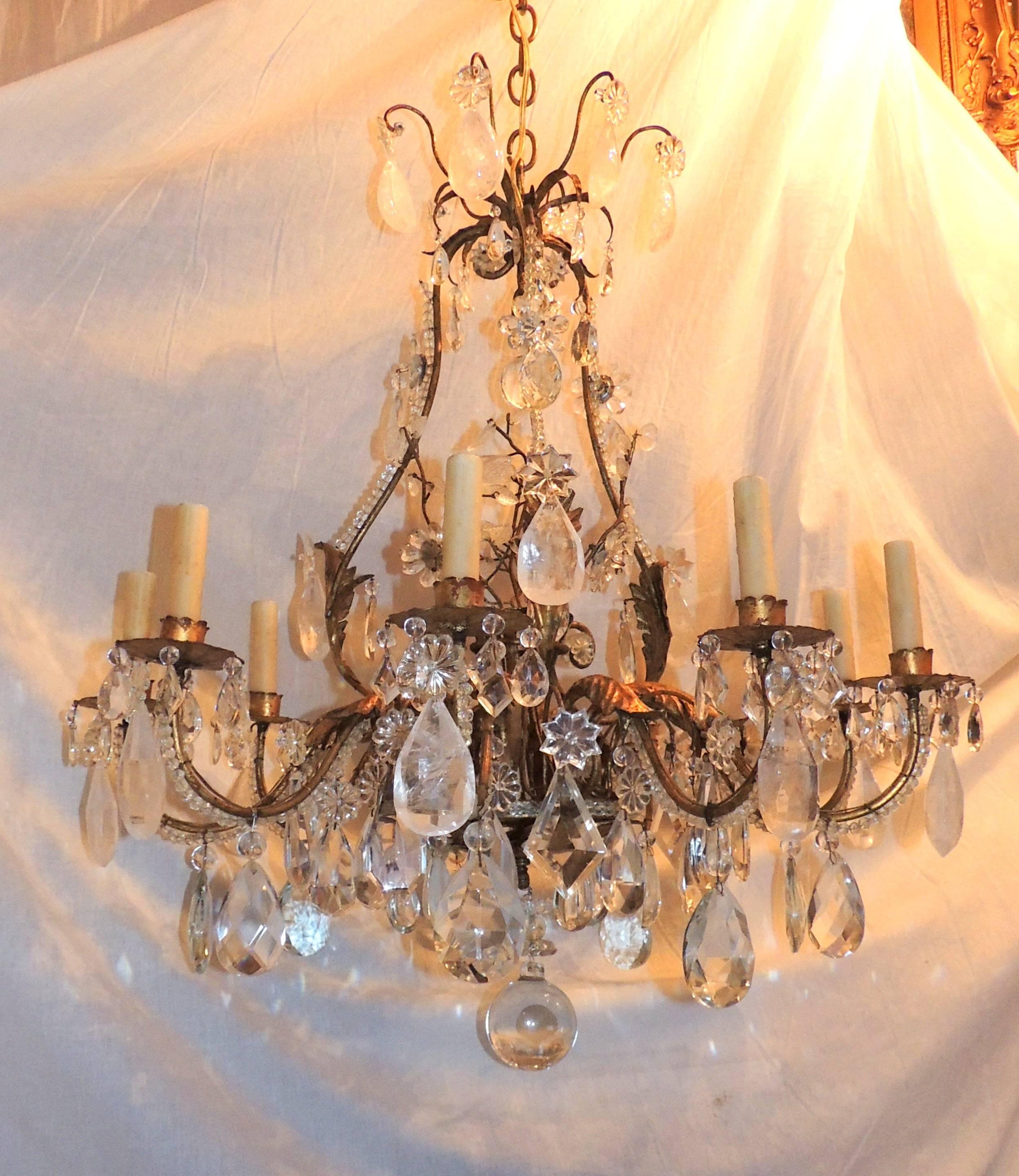 Gilt metal Baguès rock crystal nine-light chandelier.

This wonderful chandelier has crystal beads and crystal leaves through the center and the bottom and a wonderful variety of crystal pendants, prisms and rock crystal throughout. 

Measures: