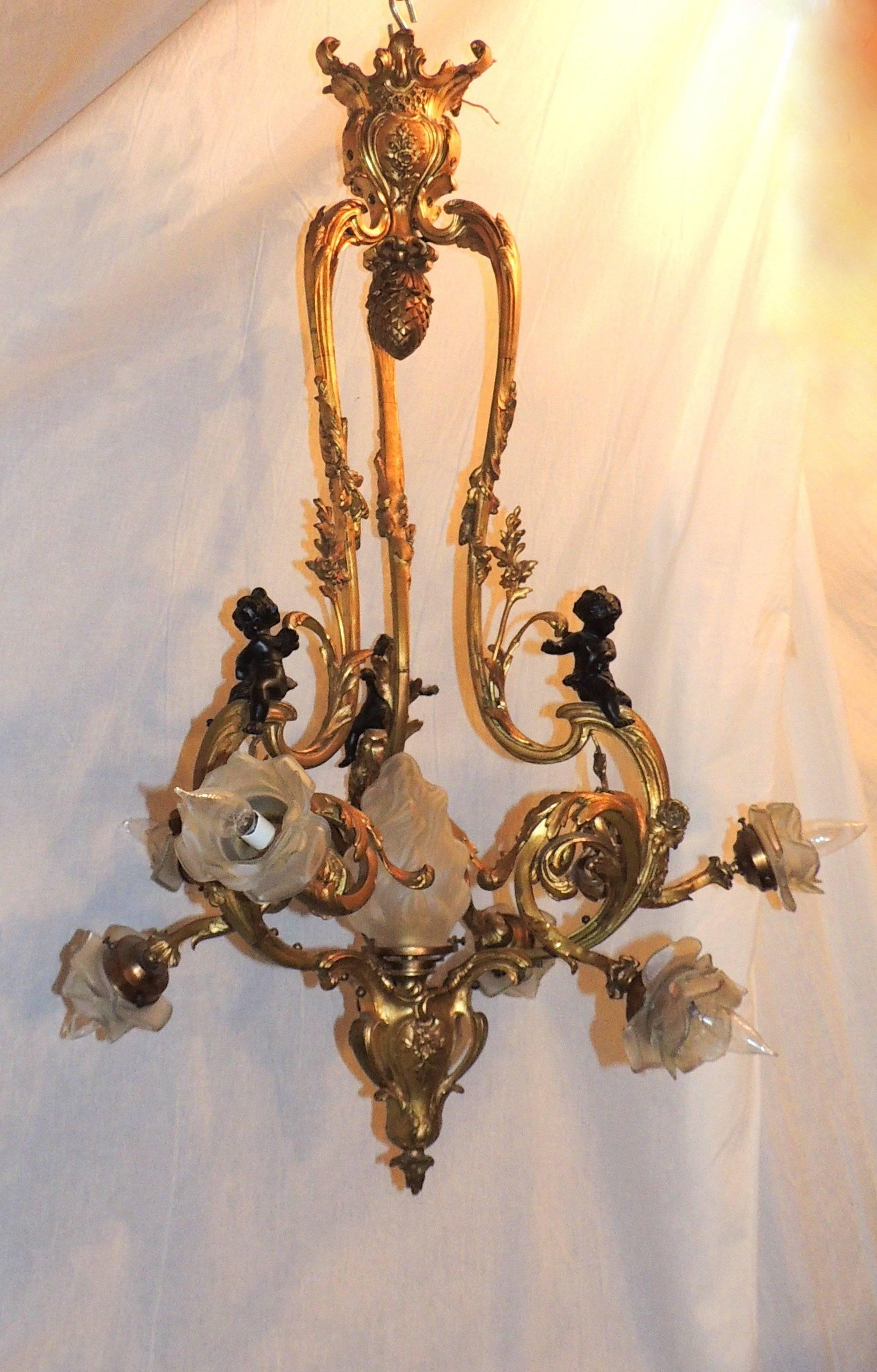 A wonderful 19th century French doré and patina bronze seven-light cherub / putti large chandelier with rose bud shades. 
Measures: 42