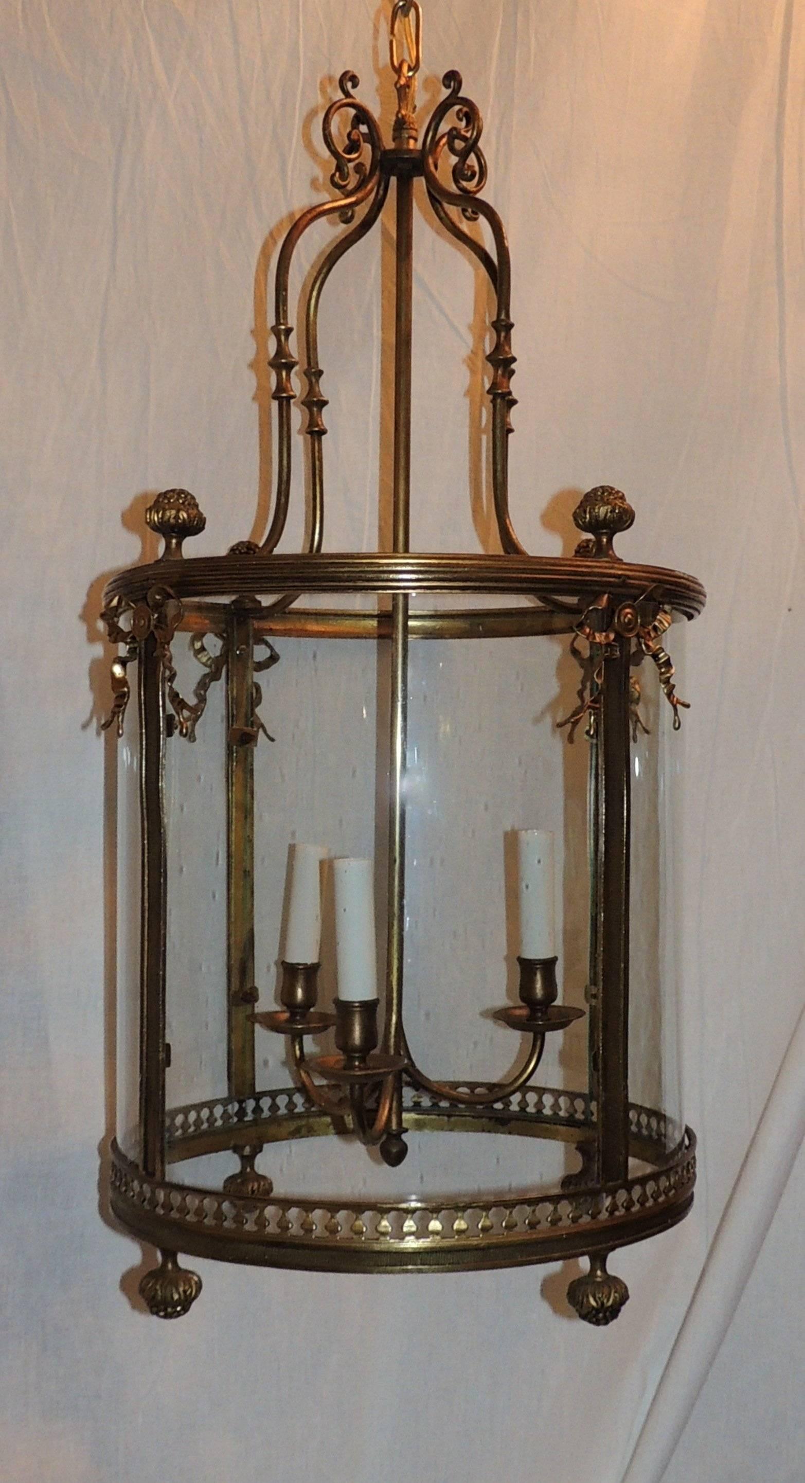 A Beautiful etched bronze with draping bow lantern, pendant lantern fixture with cutout design around the bottom, fluted and filigree edges the top edge and ribbon bows highlight the side panels.

Measures: 29