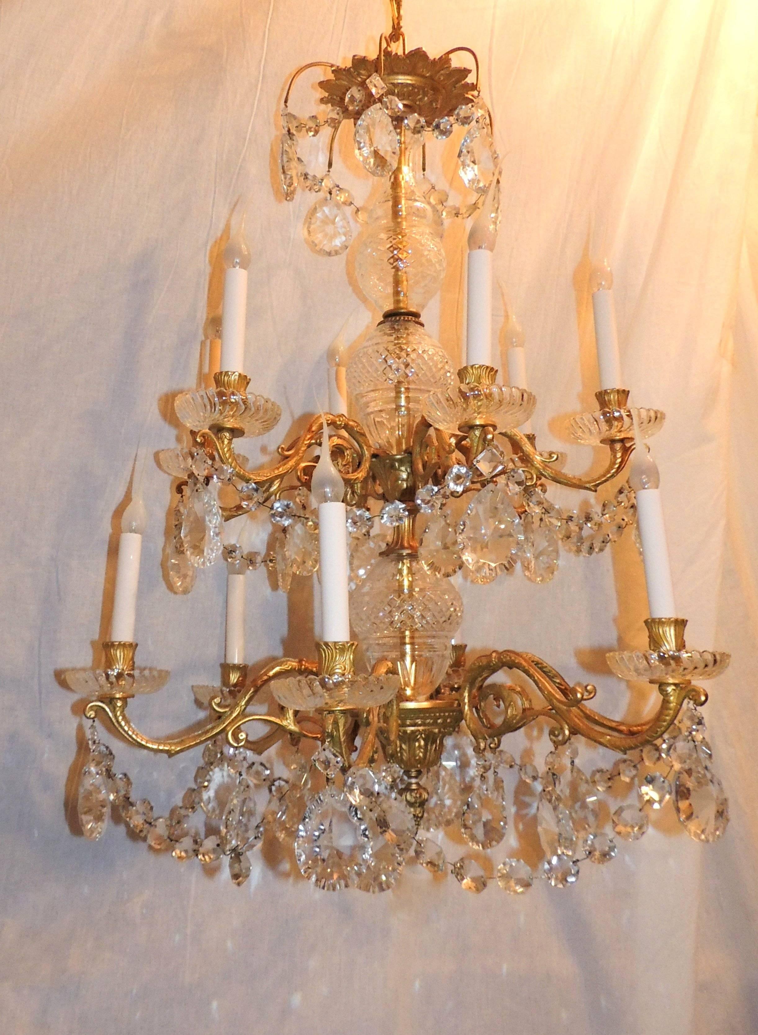 Wonderful doré bronze three-tier 12-arm chandelier with beautiful cut crystal center and draped crystal accenting the tiers finished with floral and filigree detail on the bronze chandelier and canopy.

Measures: 36