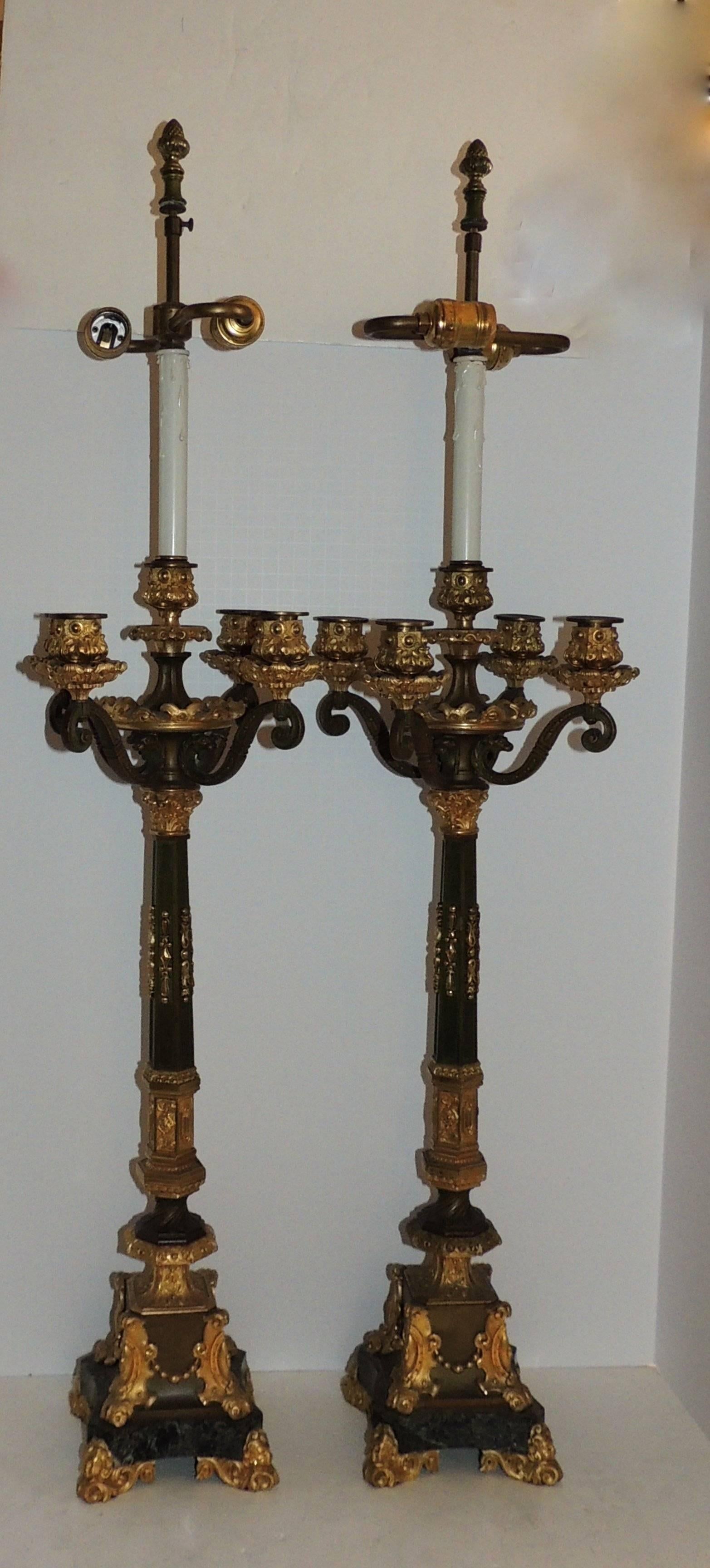 A beautiful large pair of 19th century French Empire gilt and patinated five-arm candelabra with two lights. Each of the four-arm candle cups are finished with lions faces, a have a very fine filigree draping on the marble pedestal bases on the four