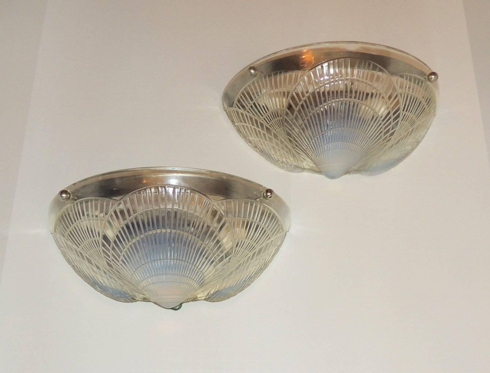 A wonderful pair of Lalique style frosted single coquille two-light molded opalescent Art Deco glass wall sconces

Measures: 5" D x 11-5/8" L x 5 5/8" W.