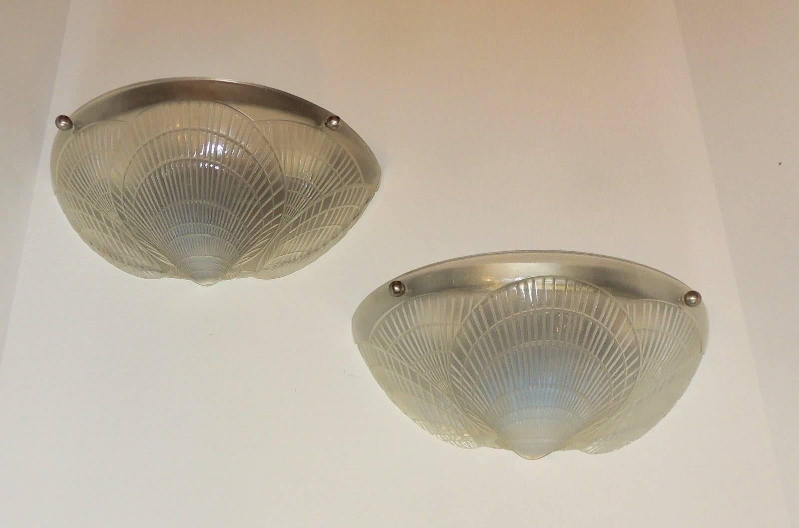 A wonderful pair of Lalique style frosted single coquille two-light molded opalescent Art Deco glass wall sconces

Measures: 5" D x 11 5/8" L x 5 5/8" W.