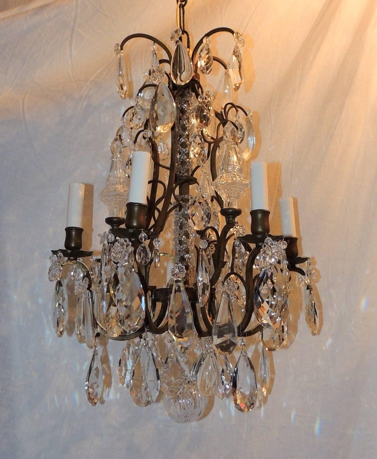 Wonderful aged bronze chandelier with crystal beaded center, six lights with large prism crystals and Obelisk spires accenting the chandelier

Measures: 24" H x 16" W.