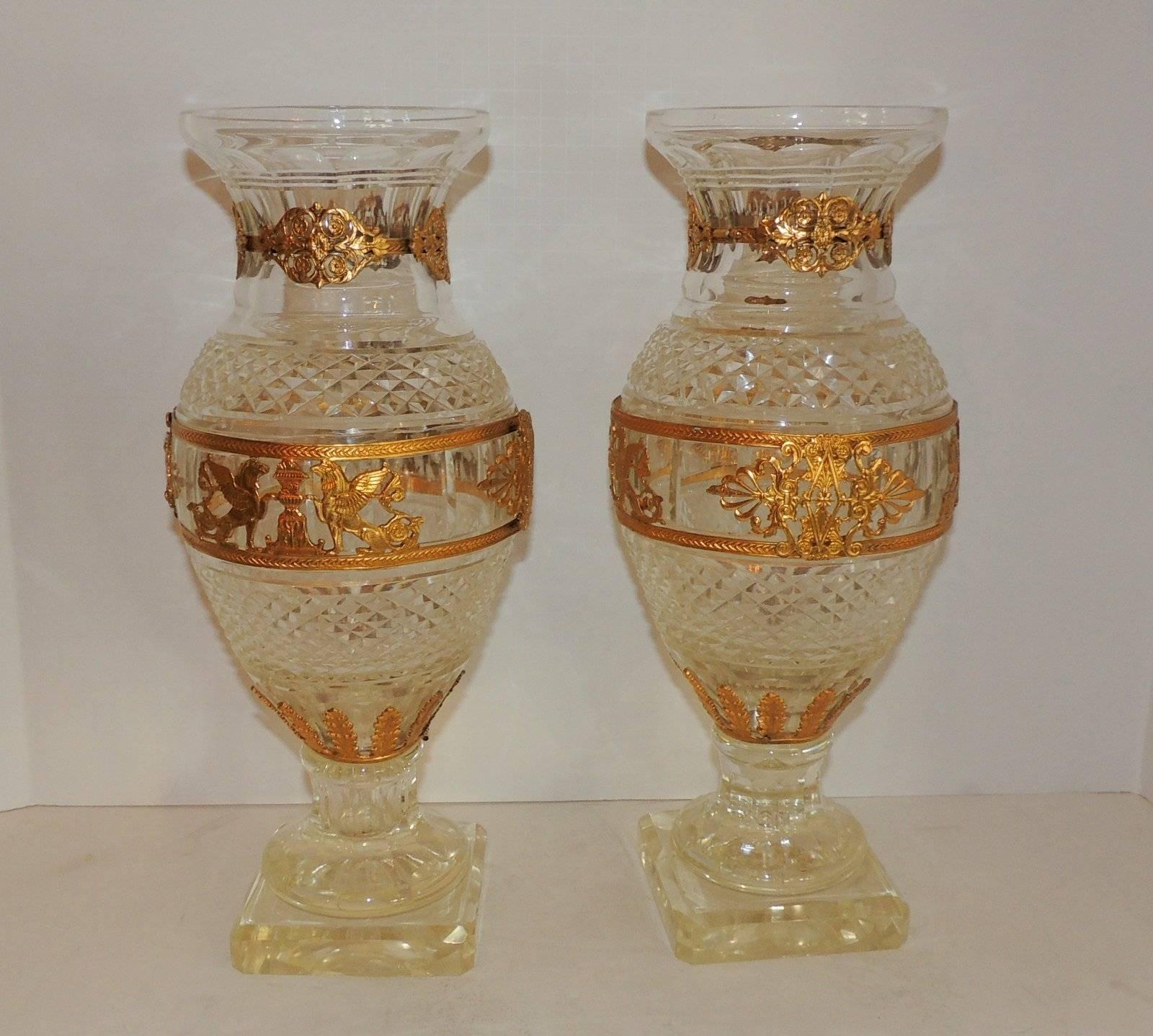 Beautiful pair of Baccarat crystal vases with pedestal bevelled base, cut crystal through the centre and gentle fluting on the base and at the top of the vase.
The gilt ormolu bands are of a floral medallion at the top, sacred urns, flame guarding