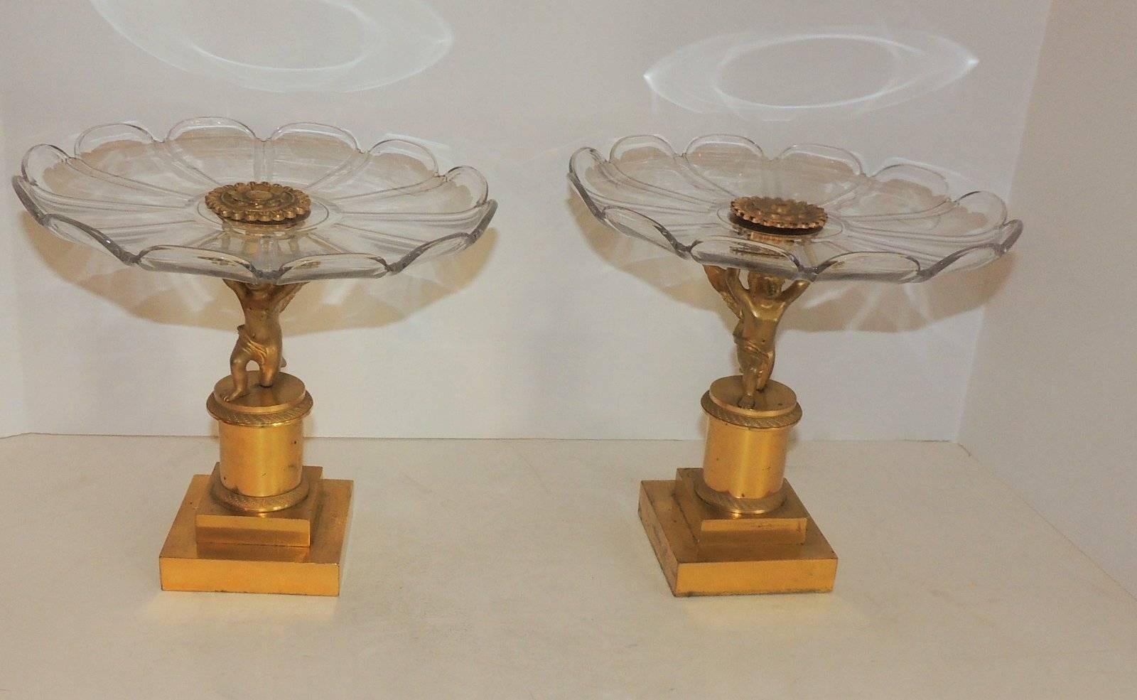 Wonderful pair of crystal scalloped compotes held by gilt bronze winged cherubs putti on etched pedestal stands.

Measures: 9