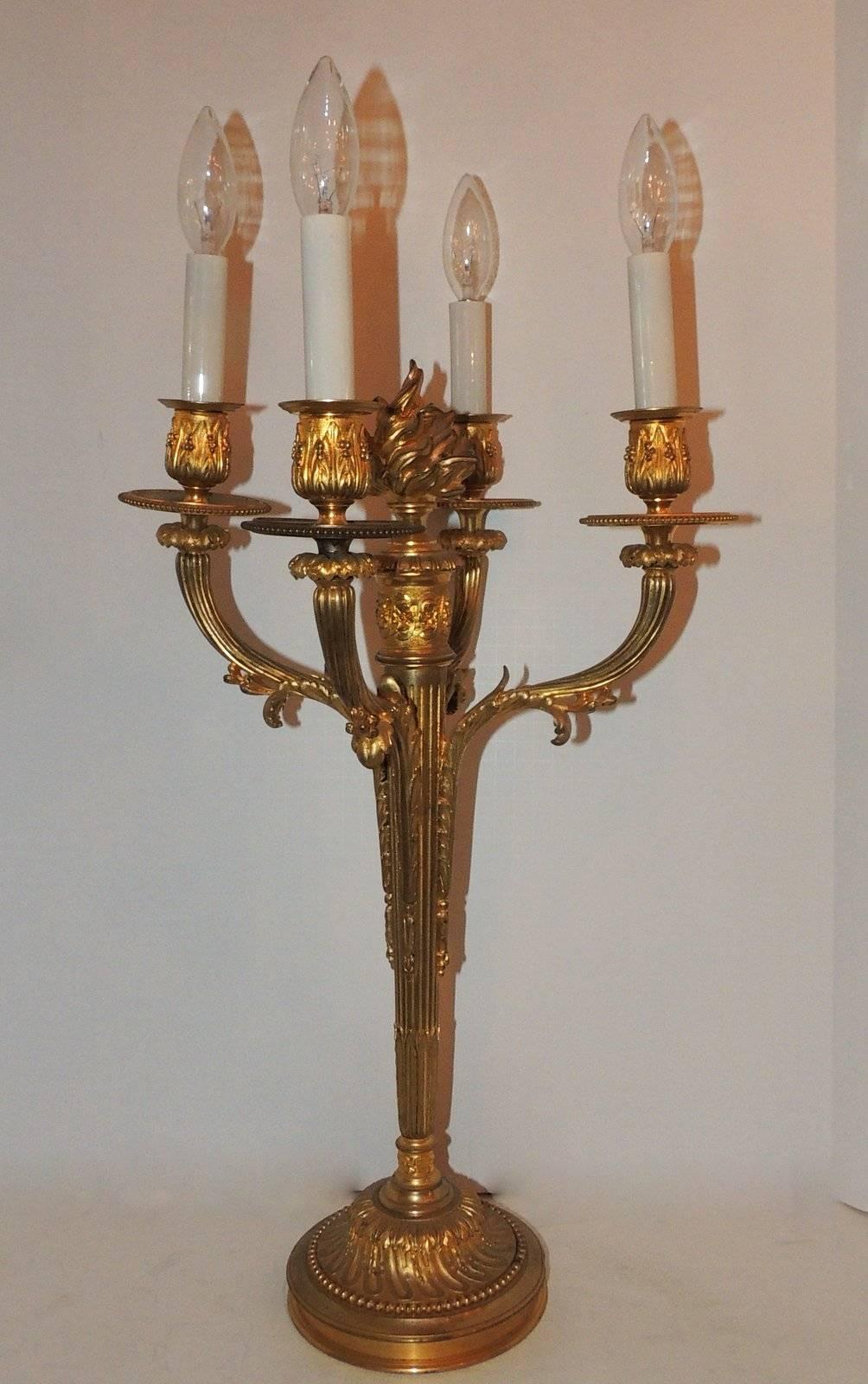 A wonderful pair of doré bronze large candelabras with centre flame, detailed surrounded by four arms with filigree, fluted center shaft and finely etched filigree pedestal base.


Measures: 24" H x 9" D x 10" W.