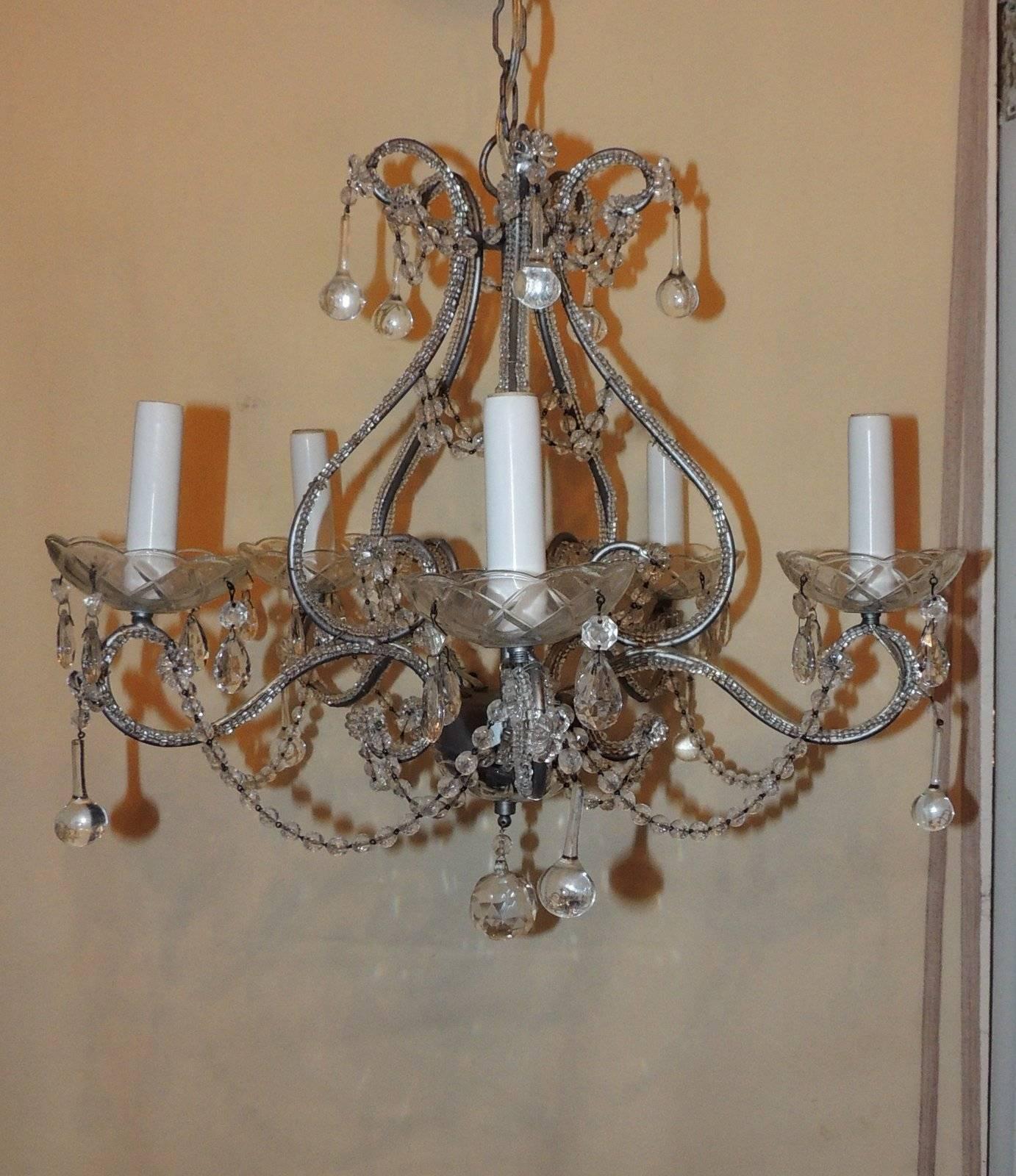 Perfect for the smaller space, this petite Bagues style five-light chandelier has crystal beads trimming the body, draped bead chains and crystal drops accenting the chandelier.

Measures: 16" H x 18" W.