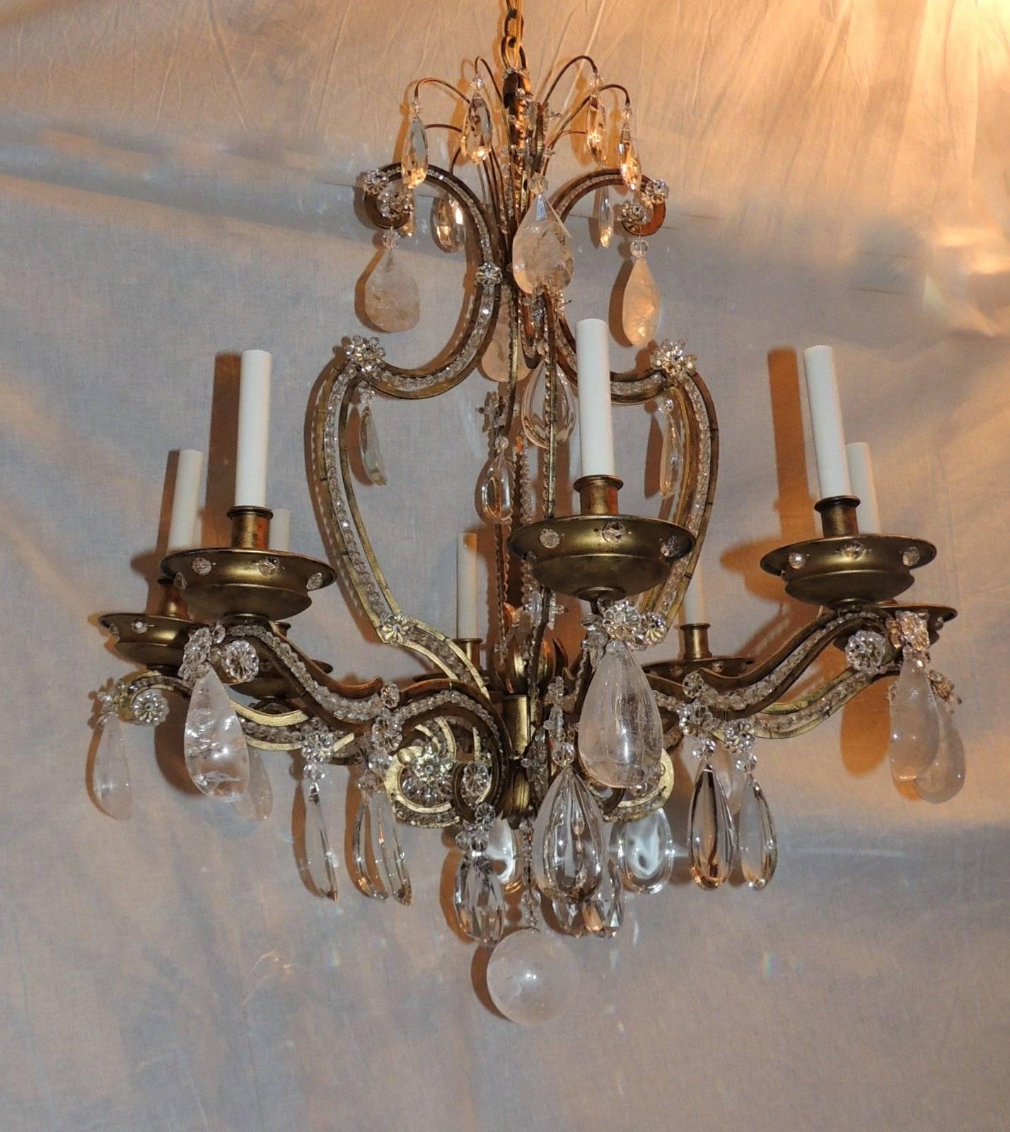 This beautiful eight-arm chandelier has the cage rimmed with crystal beads inset, rock crystal prisms at the crown and the scrolled arms, with a crystal mix at the bottom finished with a large rock crystal ball. In the center is a beautiful large