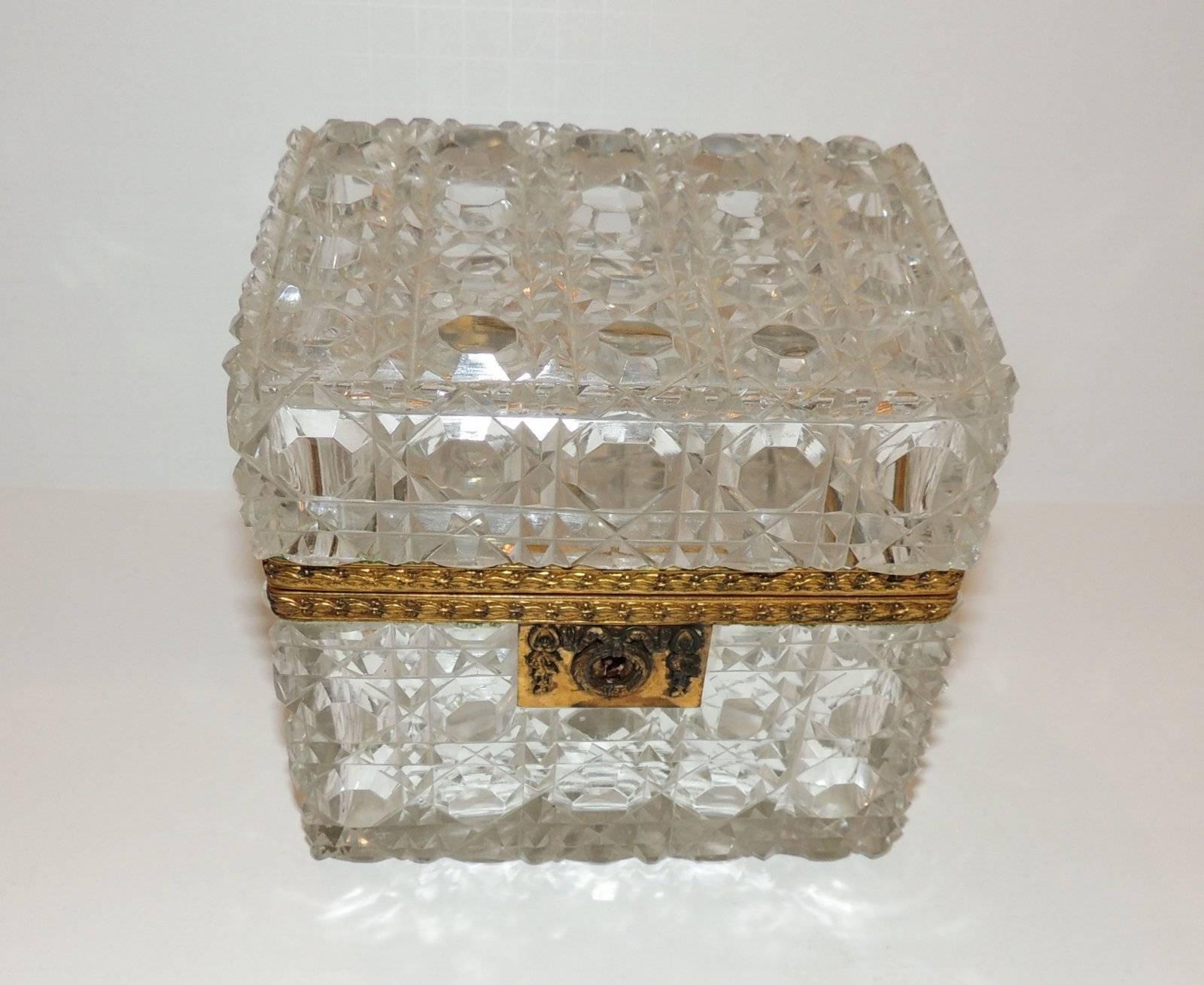 A wonderful French faceted cut crystal casket with engraved scroll bronze ormolu mountings with wreath draped keyhole.

Measures: 5.25" L x 5.25" H x 4" D.