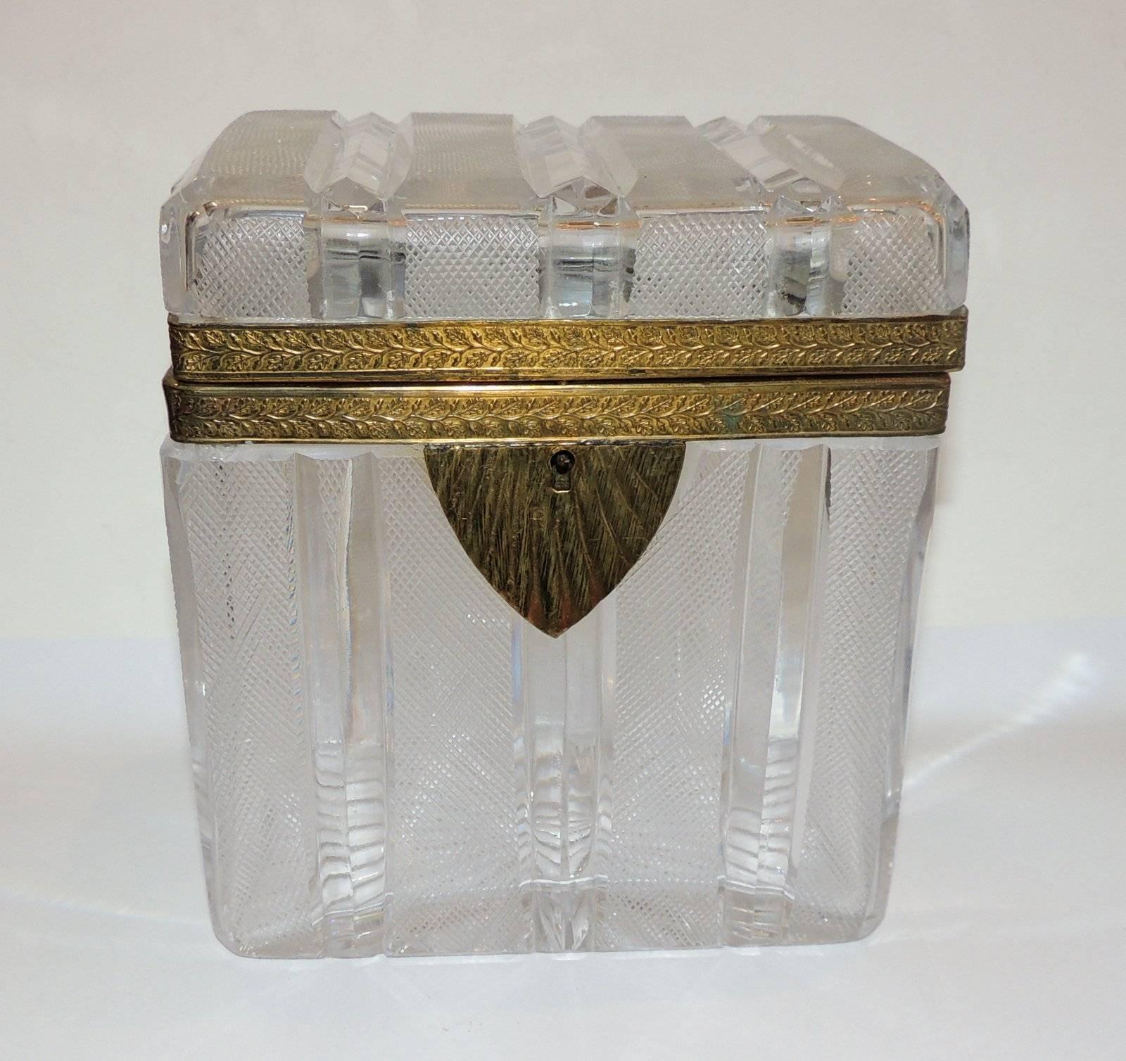 A wonderful French faceted etched cut crystal casket with engraved scroll bronze ormolu mountings with deco keyhole.

Measures: 3.25" D x 5.25" L x 6" H.
