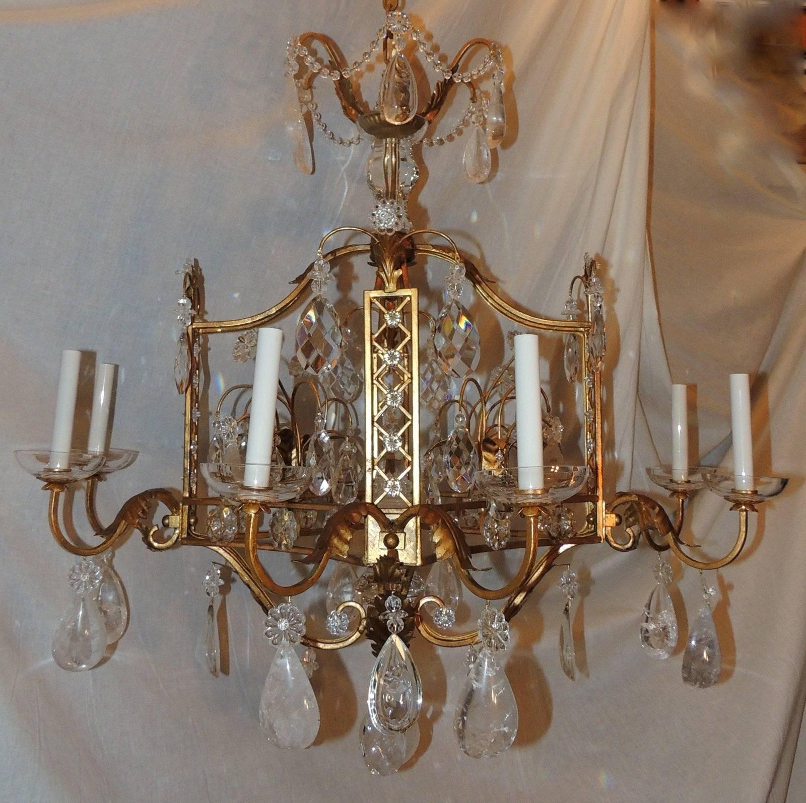 A wonderful French Louis XVI style Baguès motif eight-light chandelier featuring faceted cut crystal, rock crystal on a gilt metal pagoda form with crystal rosettes framing the sides and gilt leaves accenting on the arms and clear crystal bobeches.