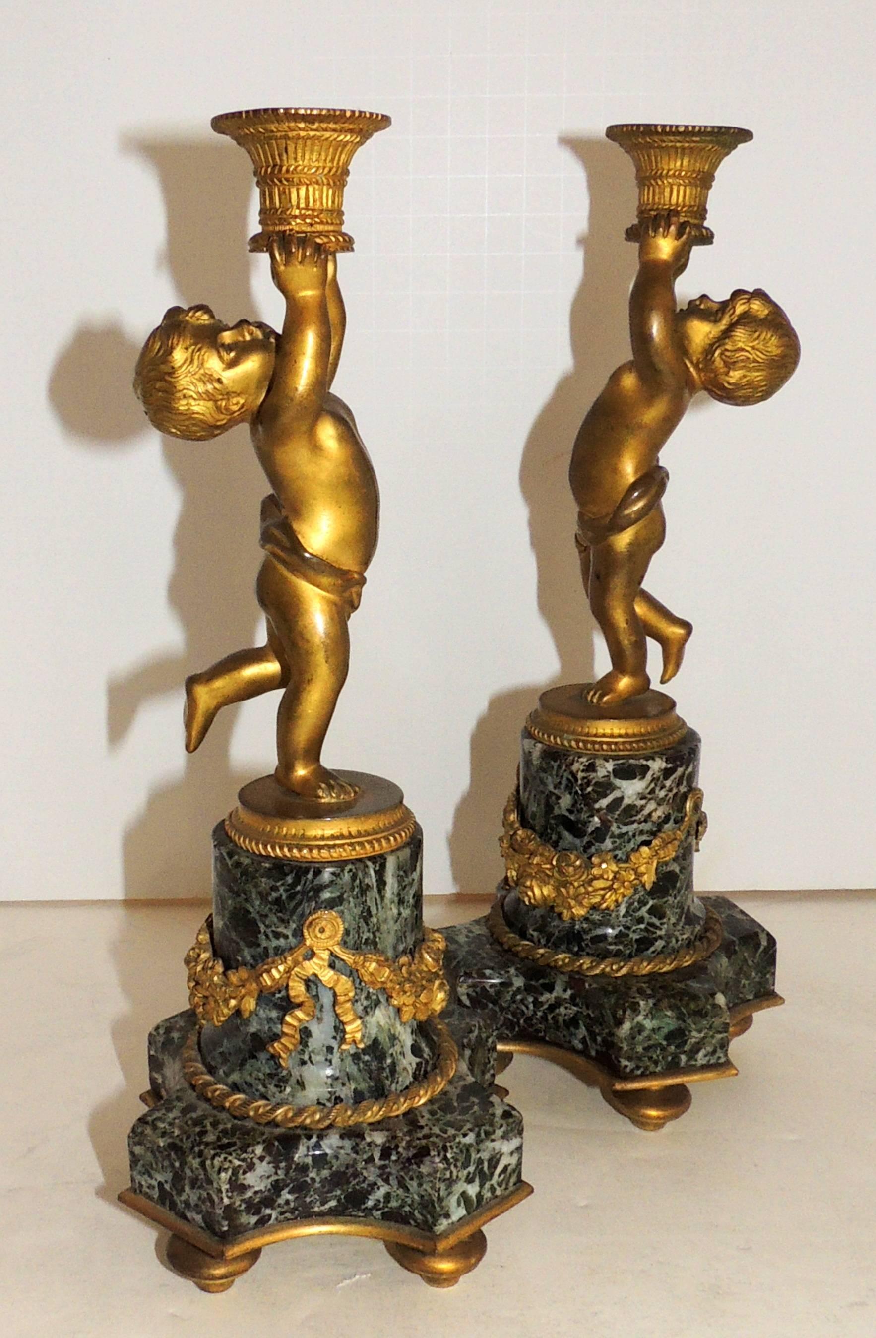 A wonderful sweet pair of French gilt doré bronze cherub or putti ormolu-mounted swag on marble base candlesticks holding a basket candleholder
Measures: 11