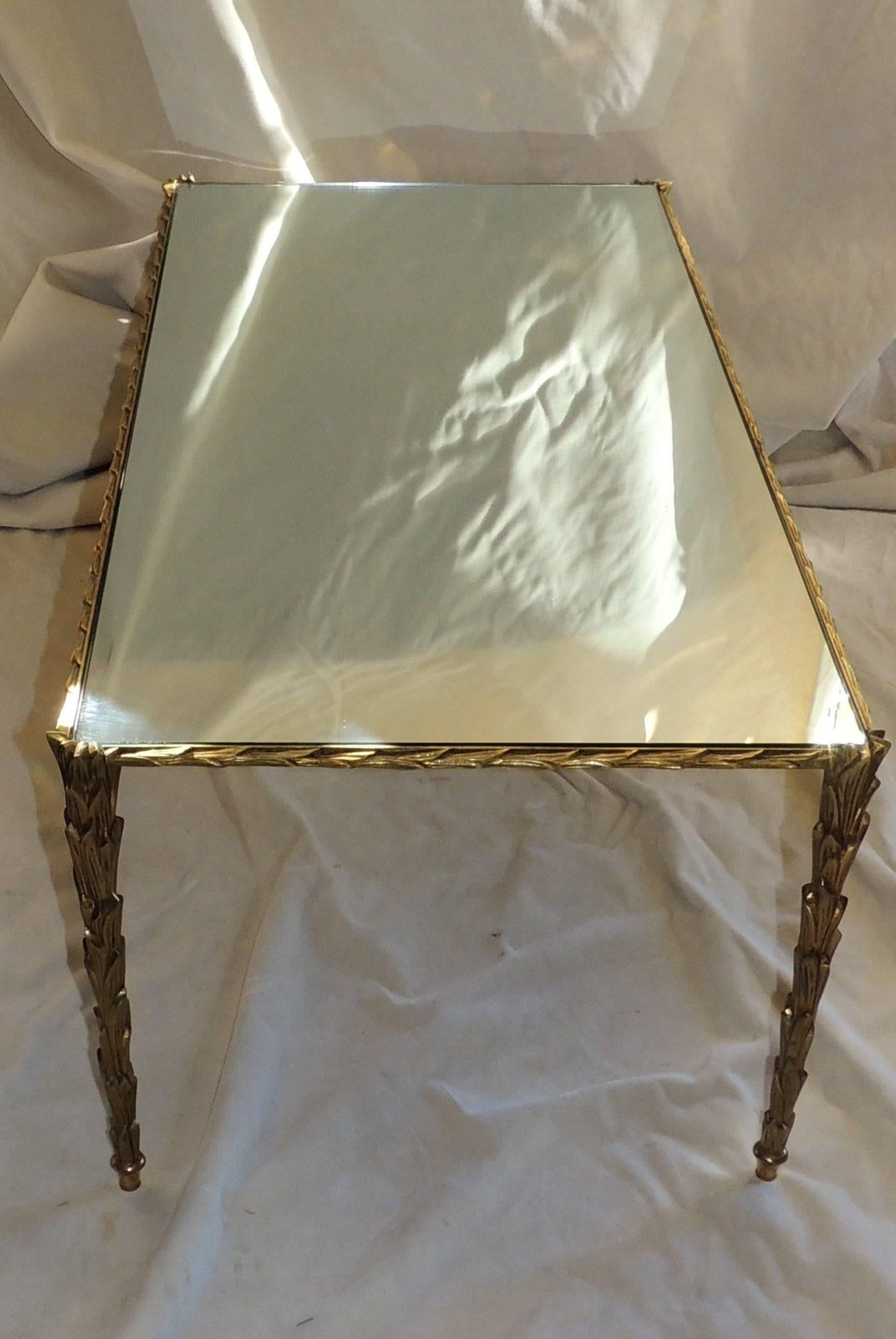 An elegant hand chased gilt bronze in the palm leaf design with a Polished mirror coffee table top.
In the manner of Bagues, Guerin and Jansen

Measures: 21 W x 42 L x 15.25 H.