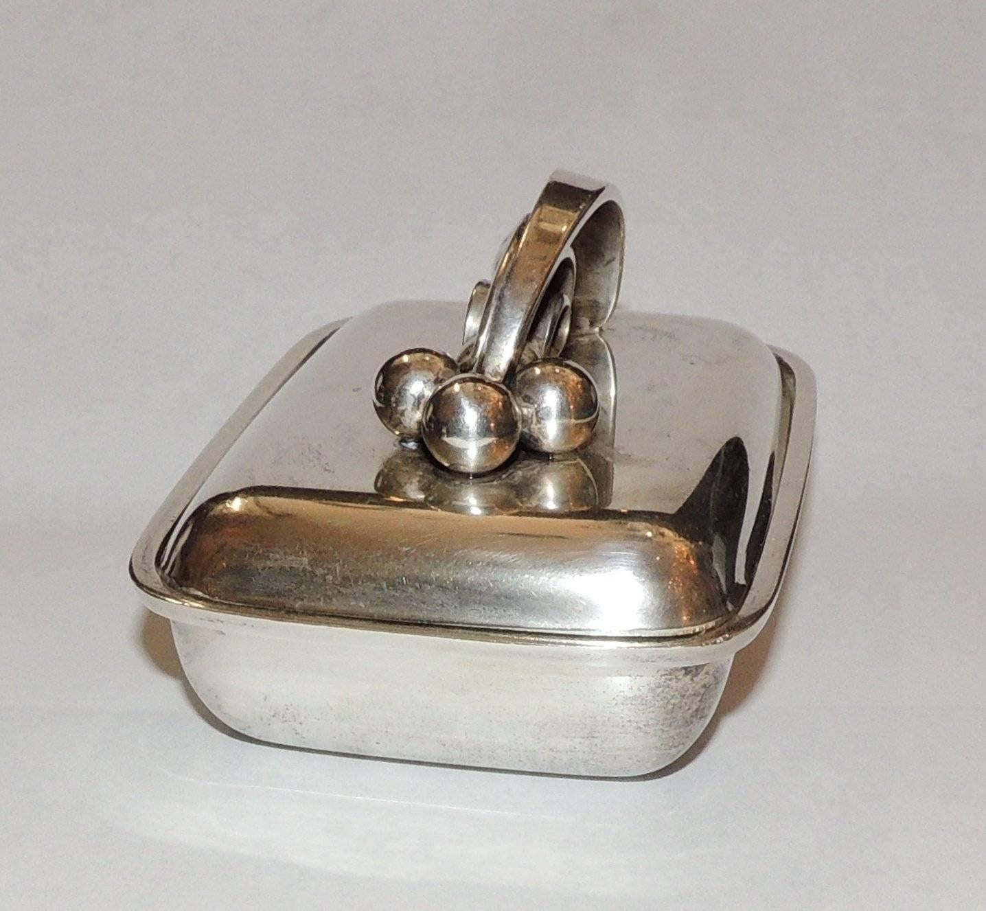 Alphonse La Paglia sterling silver modern covered box with unusual handle on the lid.
Lovely vintage condition.
Measures: 4" H x 3" W x 2.5" H
Approximate 193 g silver.
 