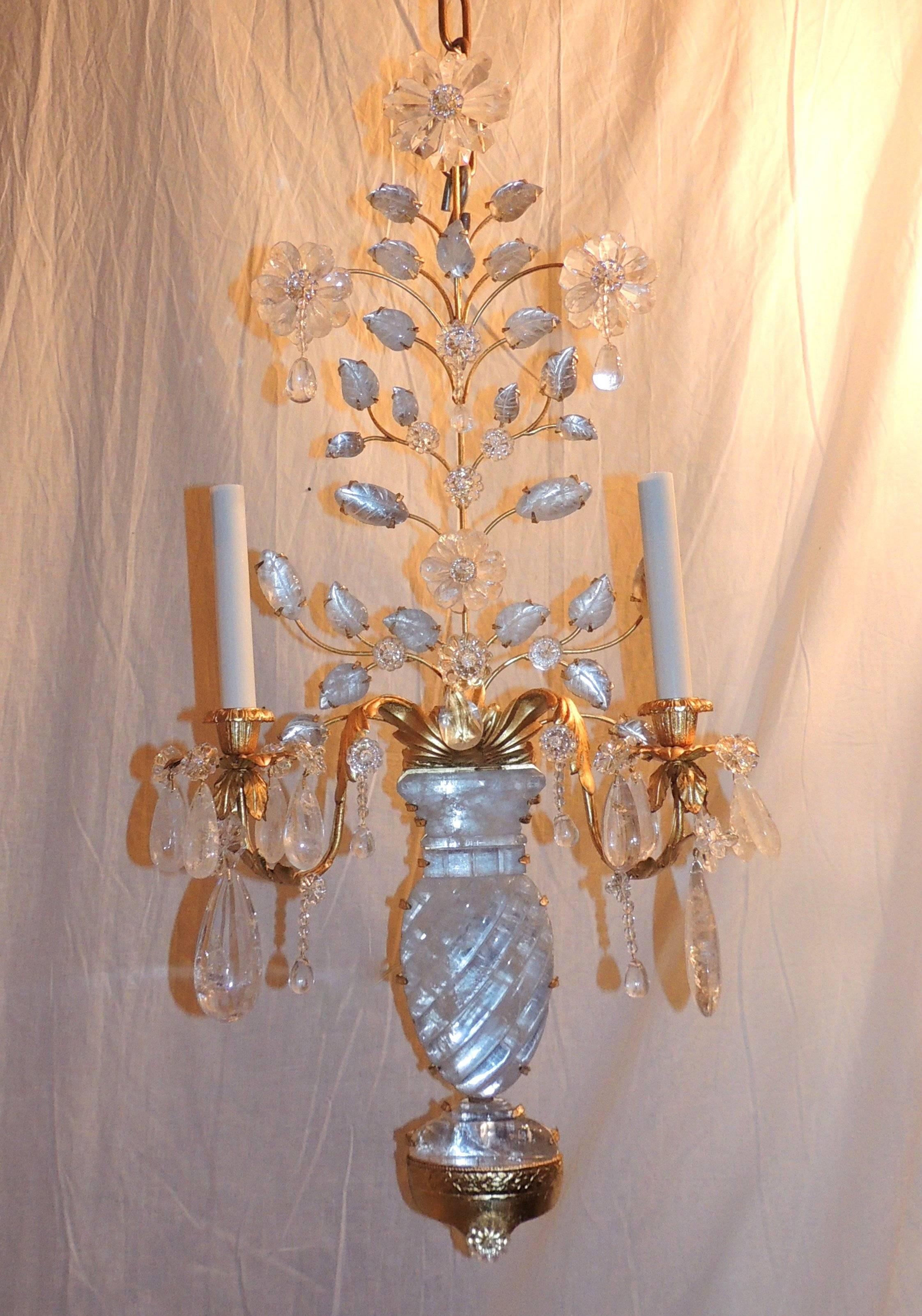 An elegant pair of gilt metal and rock crystal two-arm candelabra sconces with beautiful floral elements. The beautiful rock crystal urn detailed with swirls is surrounded by the lovely flowers and leaves that curve across the top of the