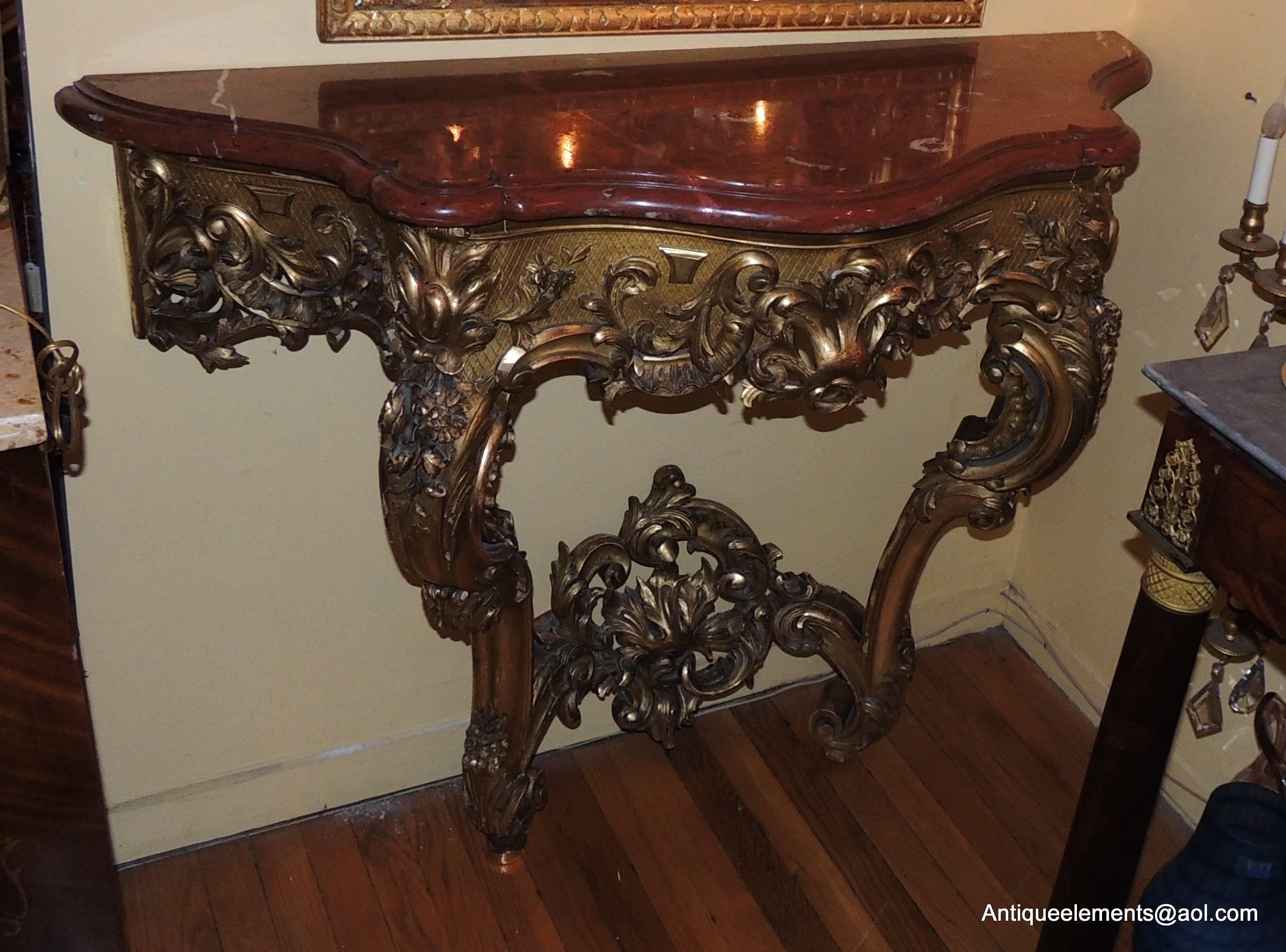 A wonderful 19th century giltwood carved console with original beautiful Rouge marble. The intricate floral and scroll carved detail make this a beautiful console for your special room or entry way. Marble has an old repair, completely