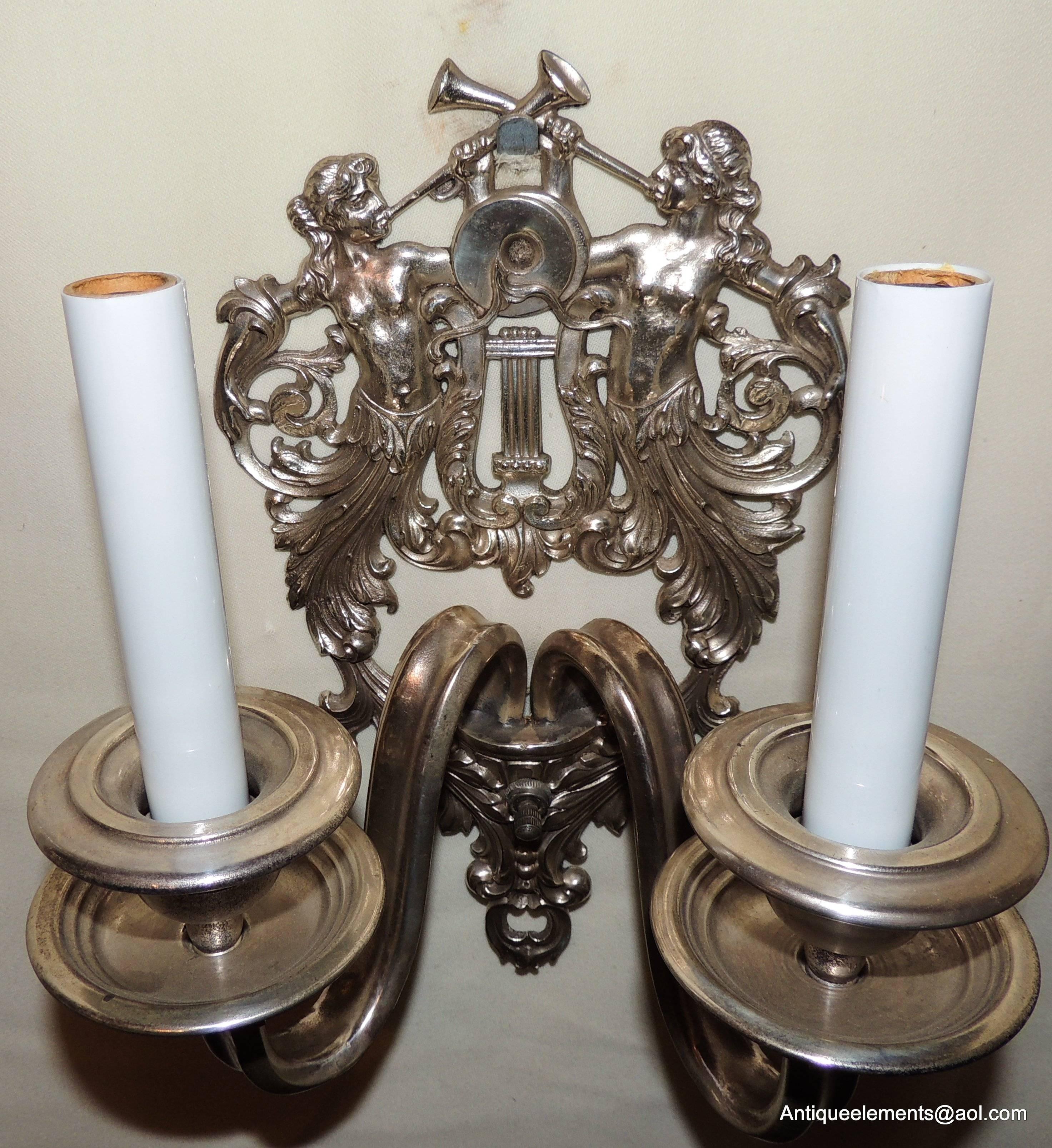 Paar zweiflammige figurale Caldwell-Wandleuchter aus versilberter Bronze mit Trompetenmotiven (Versilbert) im Angebot