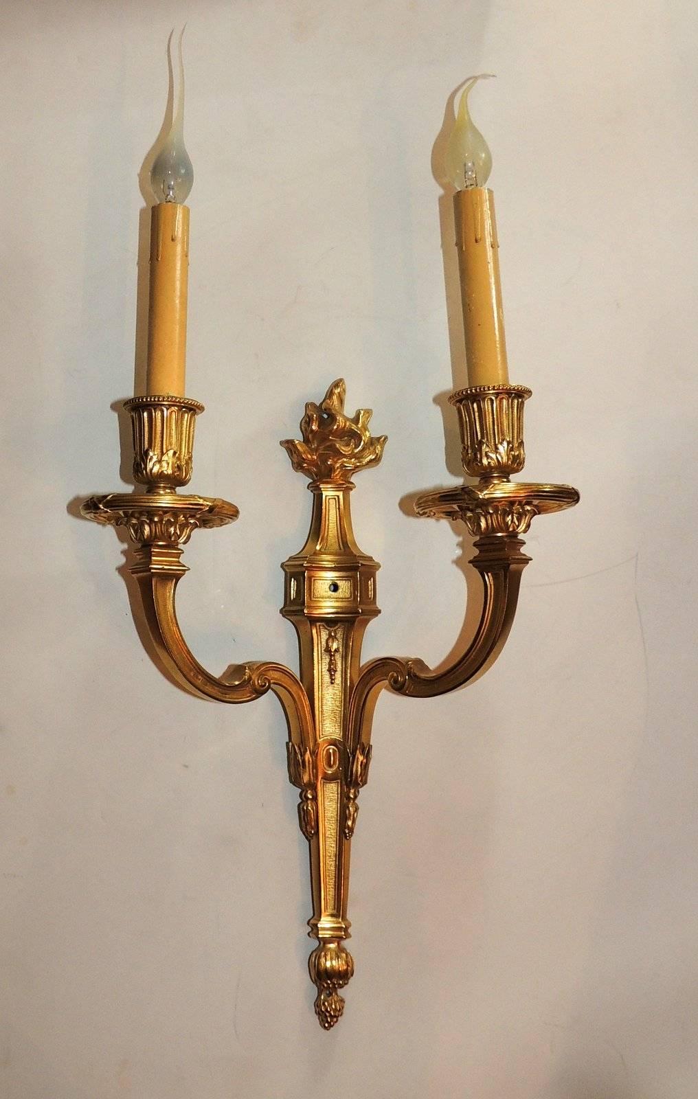 This elegant pair of Caldwell Doré bronze sconces with two arms have beautifully detailed candle cups and bobeches and are topped with a handsome flame. 

Measures: 20" H x 11" W.
  