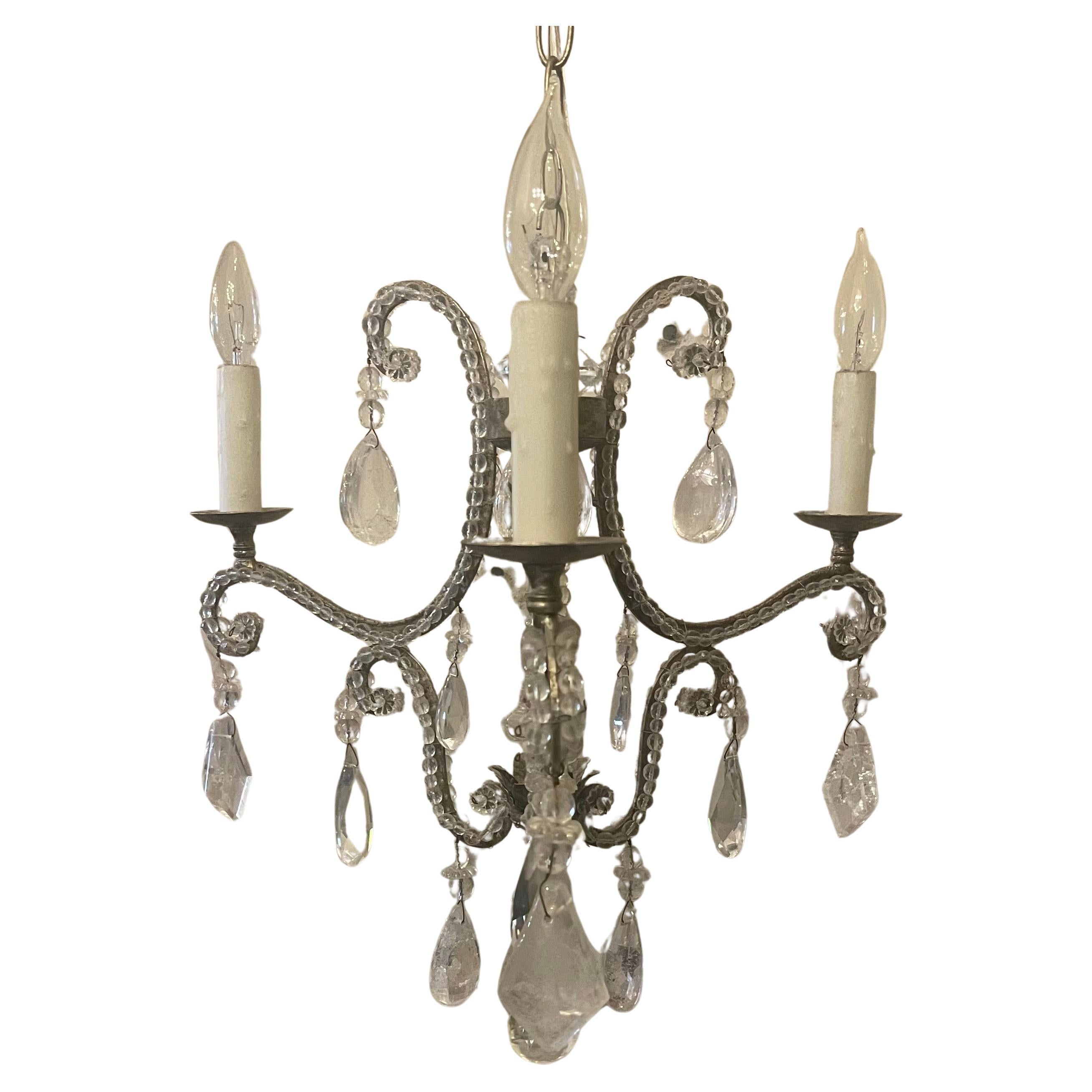 A wonderful Baguès style rock crystal, antique silver gilt and crystal beaded petite chandelier 3 candelabra light fixture centered with a crystal spike and finished on the bottom with a rock crystal ball.
By Dennis & Leen, Accompanied by chain