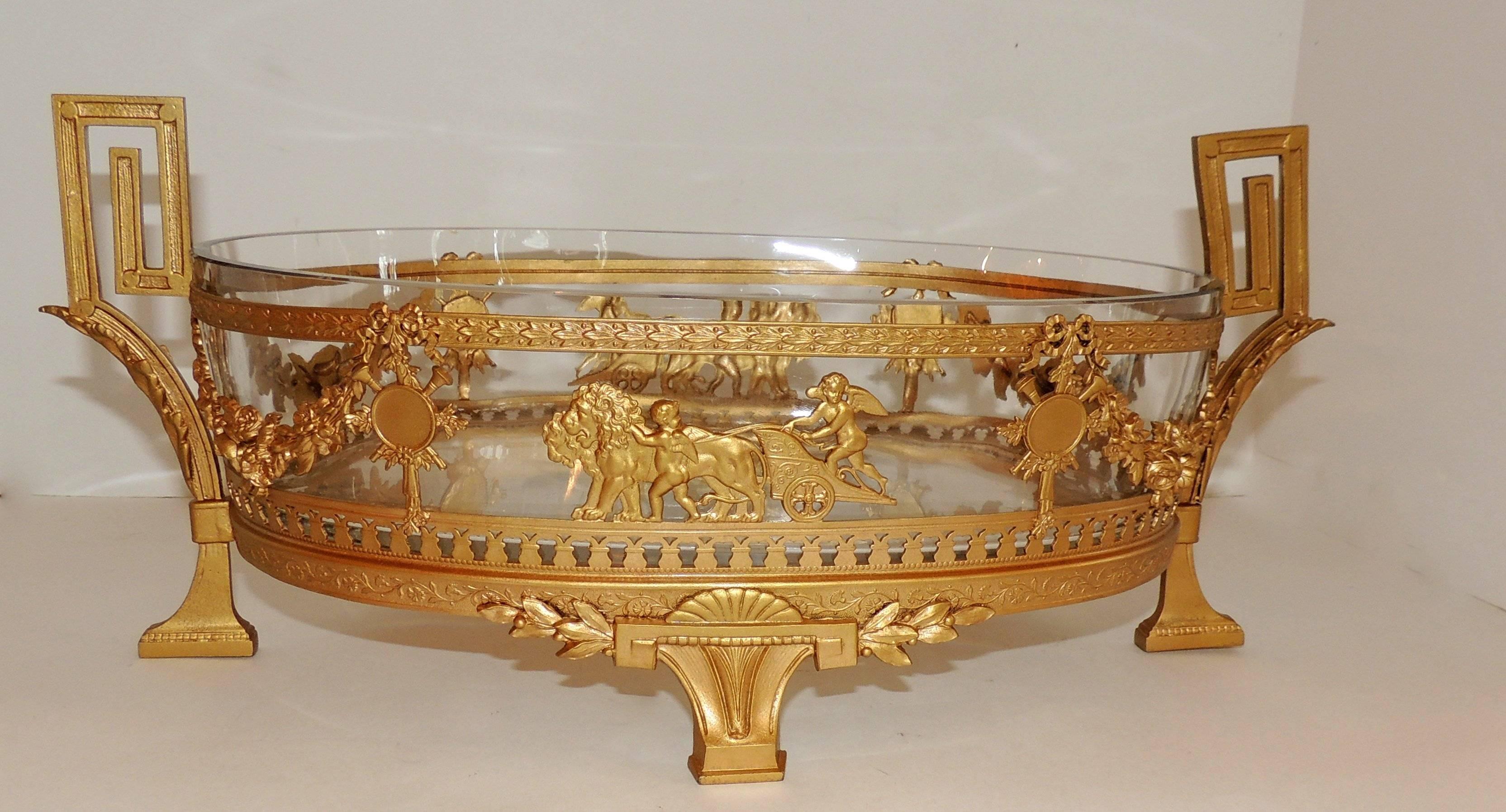 Wonderful French empire ormolu dore bronze oval neoclassical gilt glass insert centerpiece decorated with swags and musical instruments and finished in the middle with a center medallion of a putti on a chariot with horses.