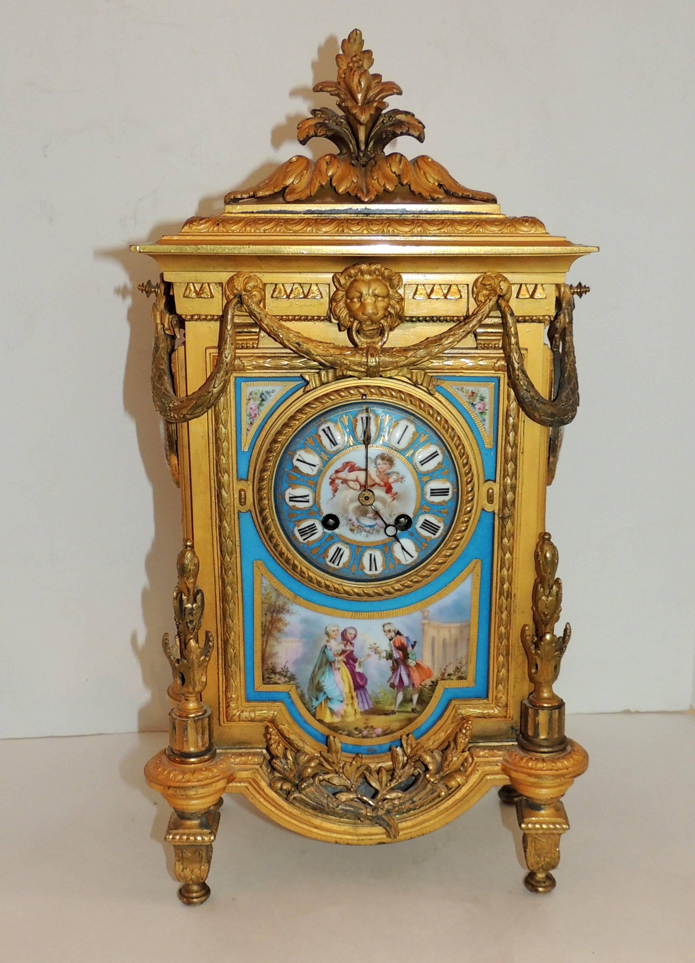 Large decorated enameled porcelain doré bronze clock, floral elements, lion mask with filigree, swags and cherub face.

Measures: 20" H x 14" W x 6" D.
 