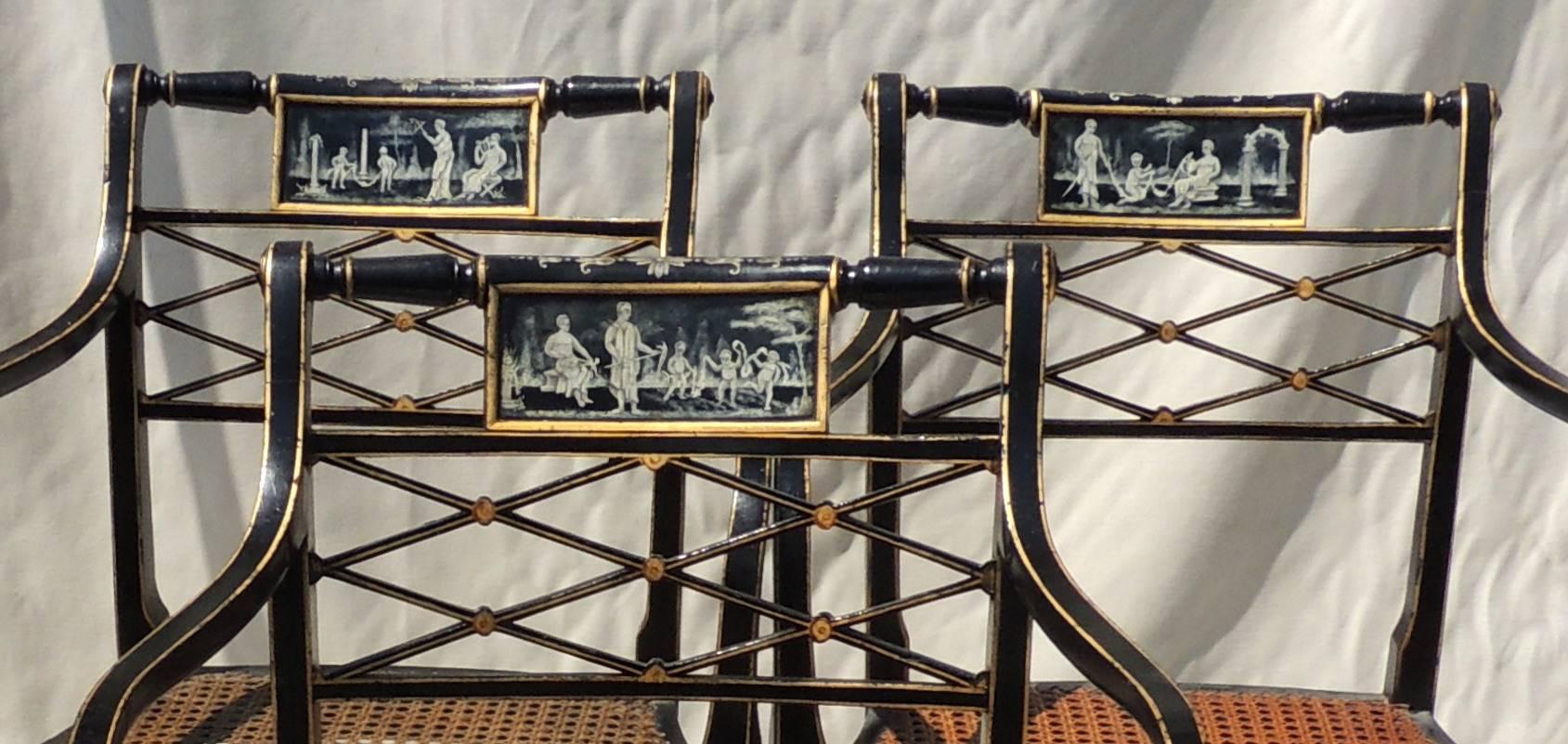 Wonderful set of 14 hand-painted black lacquered gilt caned seat vintage lattice back armchairs. Each chair is painted with a different scene, some of the chairs have been re-hand caned more recently.
They come with matching seat cushions in need