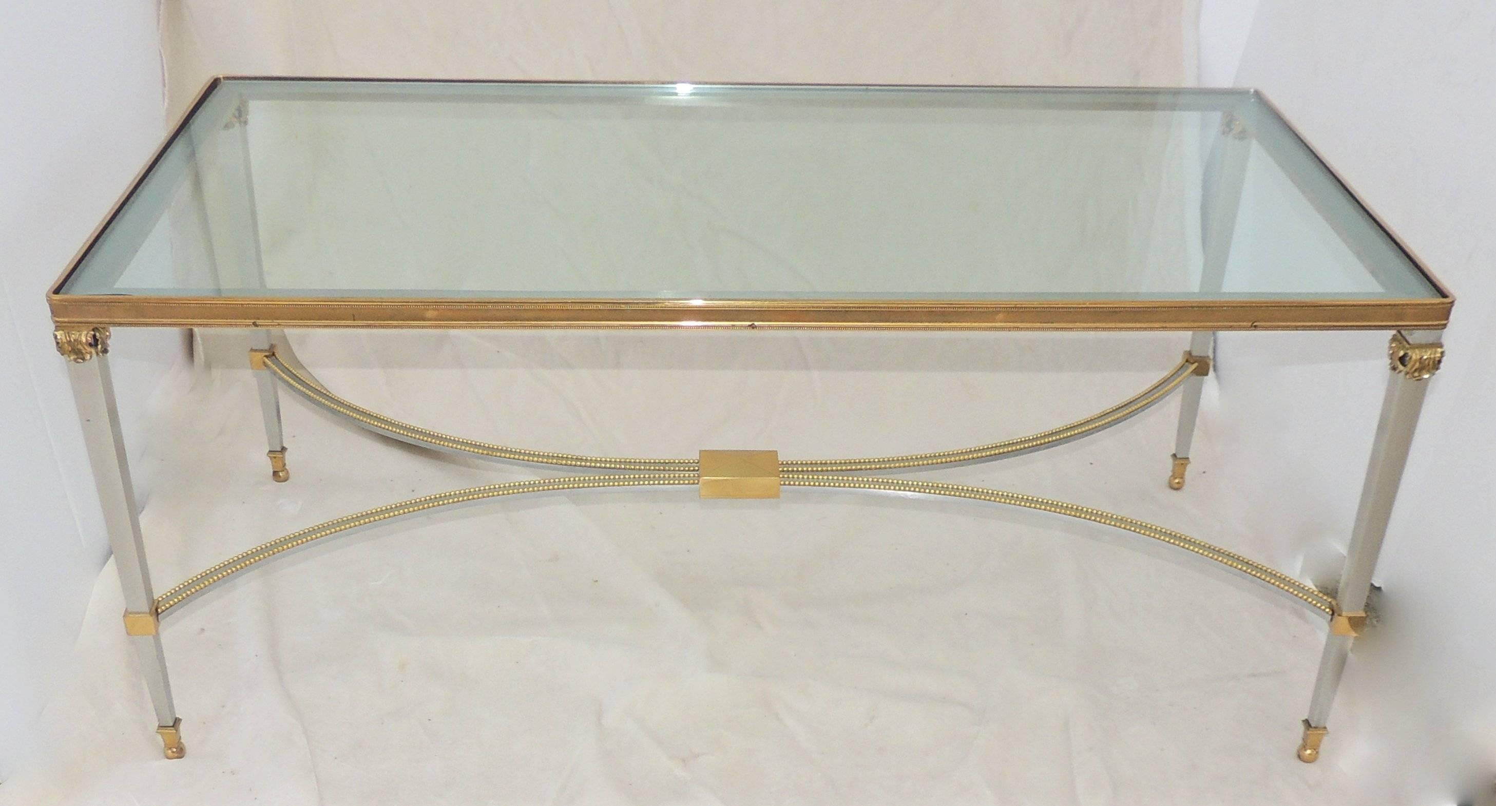 A wonderful cocktail table with silvered bronze bagues style, coffee table with inset glass top in The Jansen Style & Fine Accents.
Measures: 21" W x 41" L x 17" H.