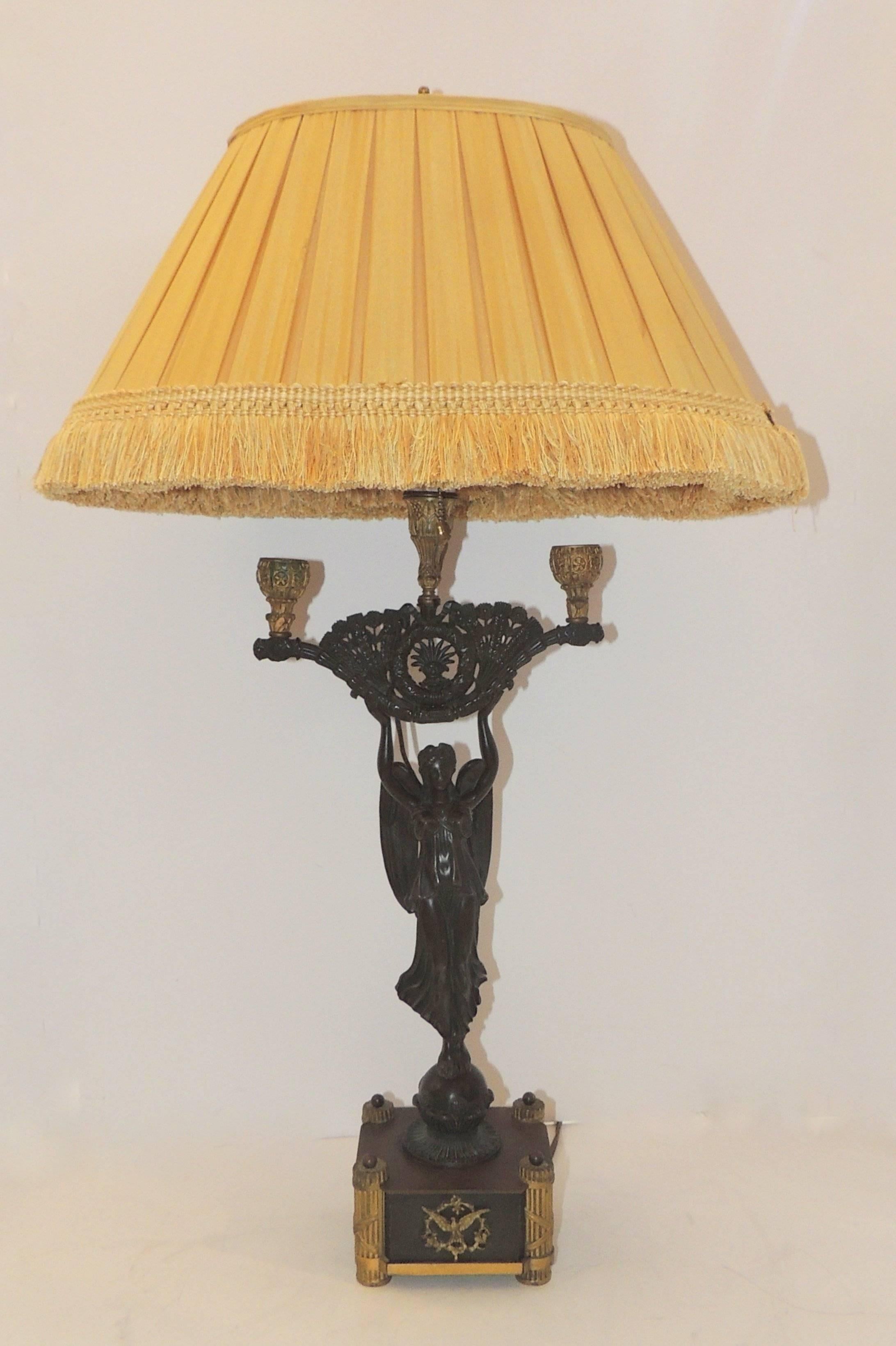 A wonderful French Empire neoclassical winged victory lady figure standing atop an orb set on a raised square bronze plinth, gilt and patinated bronze Regency lamp. Fantastic quality and detail.
Accompanied by a beautiful custom silk lampshade.
