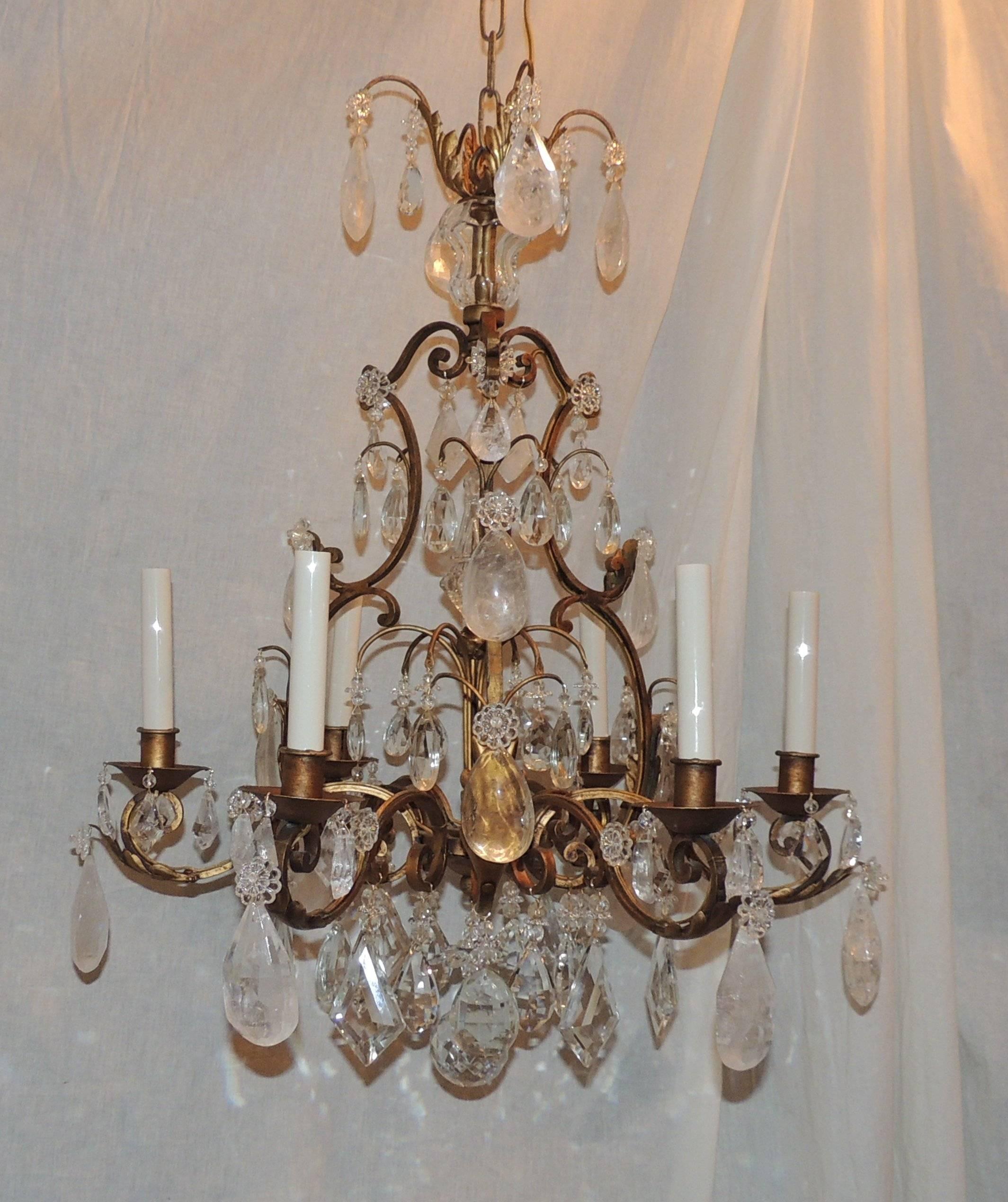 Wonderful soft scrolls accent the body of this six-arm Baguès rock crystal chandelier with center finial and lovely layers of prism and clear crystal accented by the rock crystal.

Measures: 22