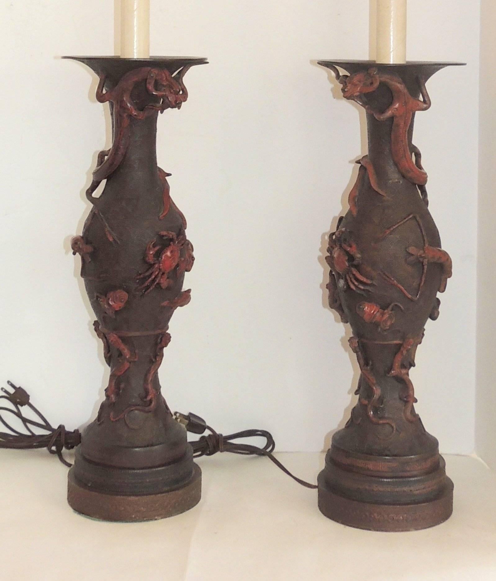 Wonderful pair of Japanese patinated bronze lamps of two facing dragons highlights this amazing pair with crabs, iguanas, koi, frogs, lobsters and hermit craps.
Measures:
Lamp 39" H x 6.5" W.

Base: 19.5" H.