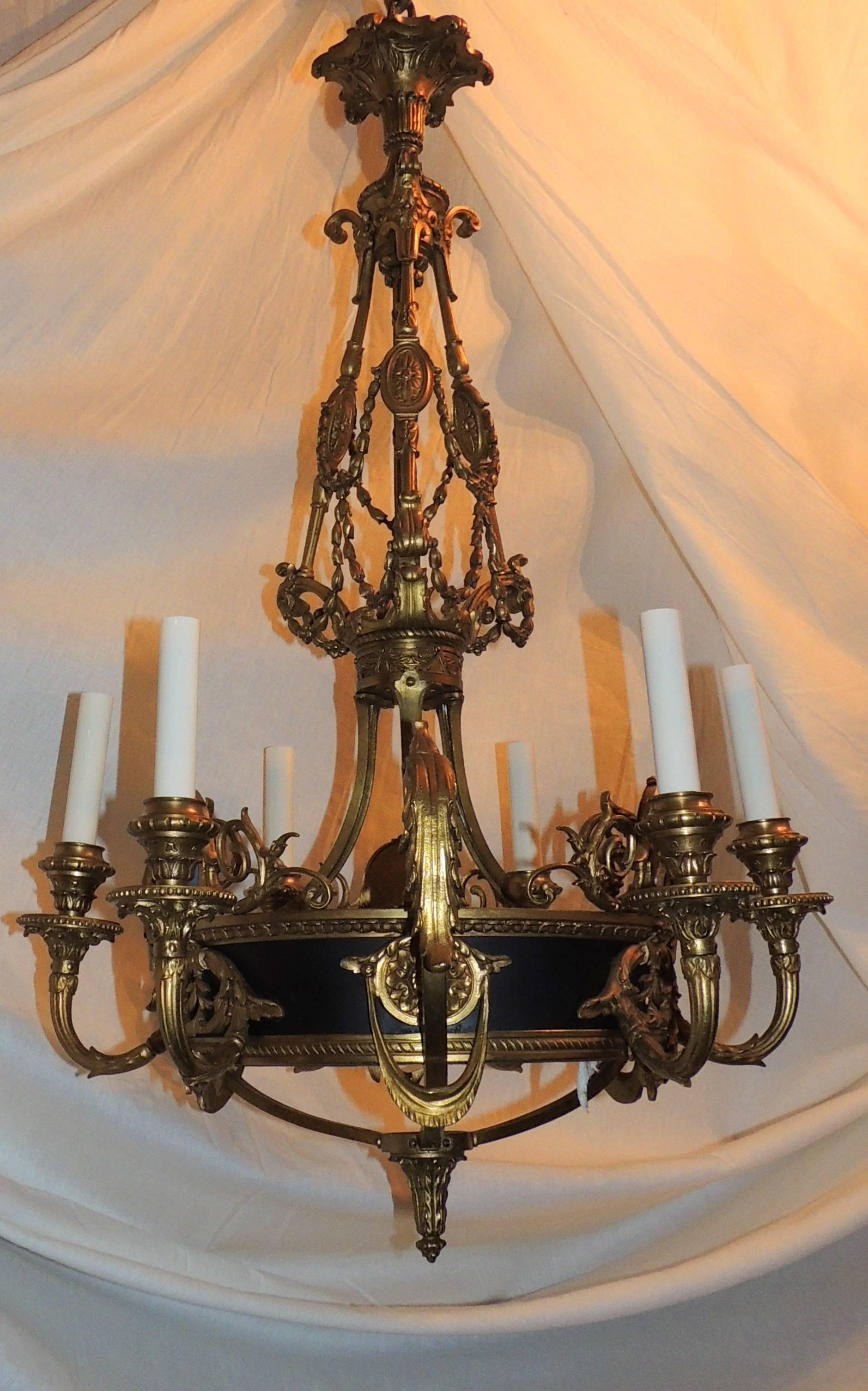 A wonderful French gilt and patina bronze chandelier inset with three wedgewood plaque and finished in the center on the bottom with a cut crystal centerpiece. In The French Louis XVI style with fine detail and open work.
Six lights on the inside,