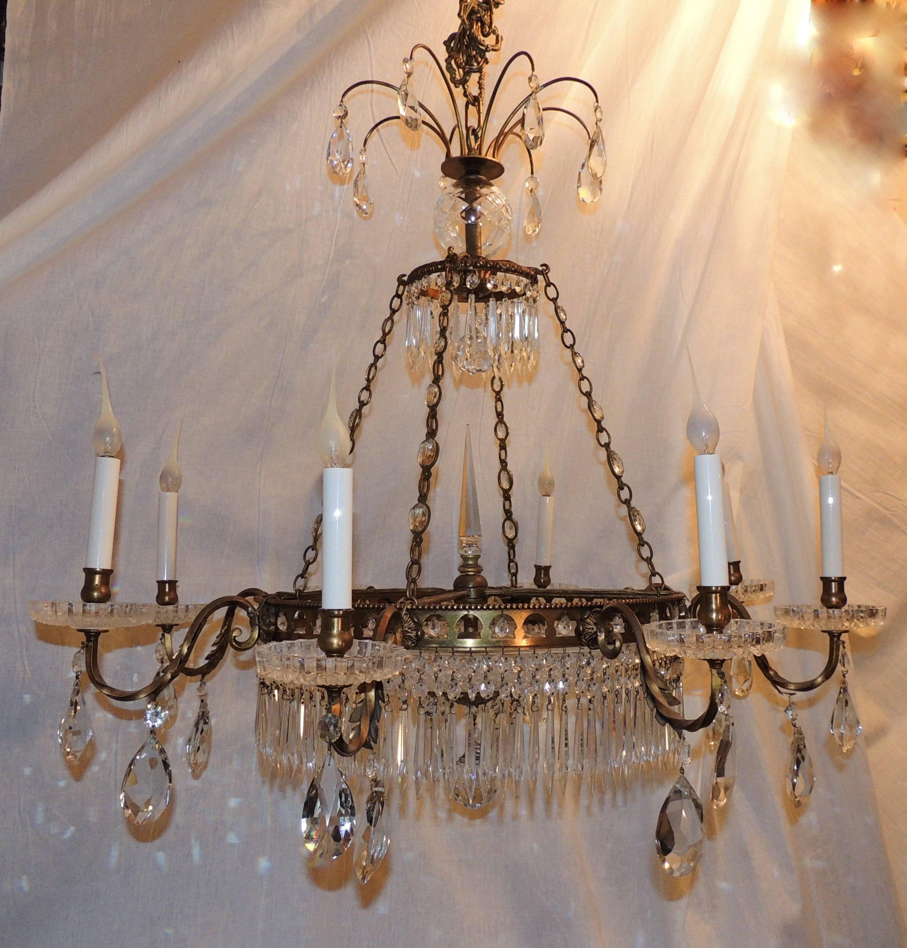 This wonderful gilt 12-light chandelier has four interior and eight arms decorated with rock crystal drops, rock crystals and crystal spears surrounding a multifaceted crystal plate. The crystals are also in the chain, the edge of the chandelier and