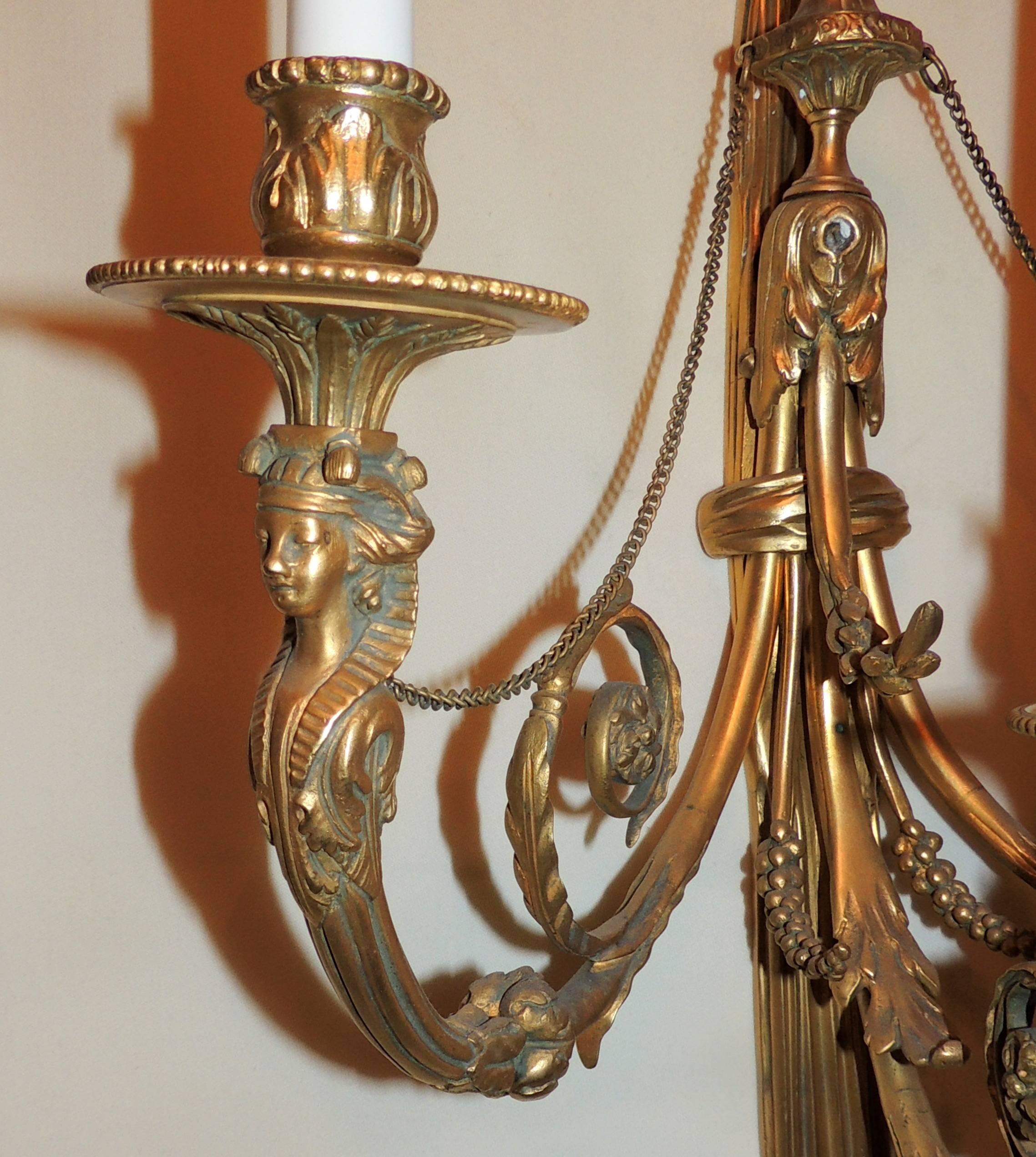 A wonderful pair of French doré bronze Regency neoclassical lady figural three-light Empire large tassel wall sconces these sconces have completely been redone and come ready to install.