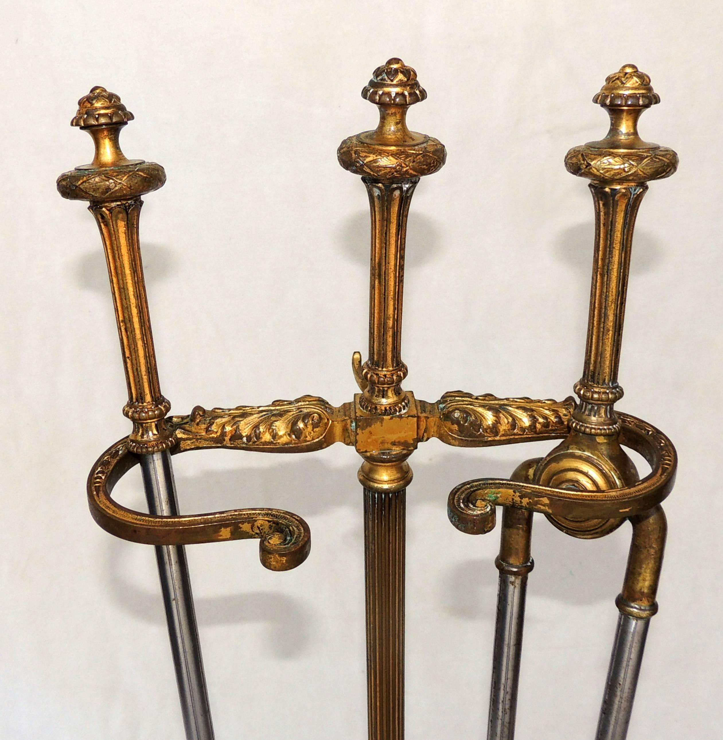 A wonderful French gilt bronze fire place three-piece tool set in the neoclassical design in the manner of Caldwell with garland swags and finials. Consisting of poker, stand, plier with steel shaft.