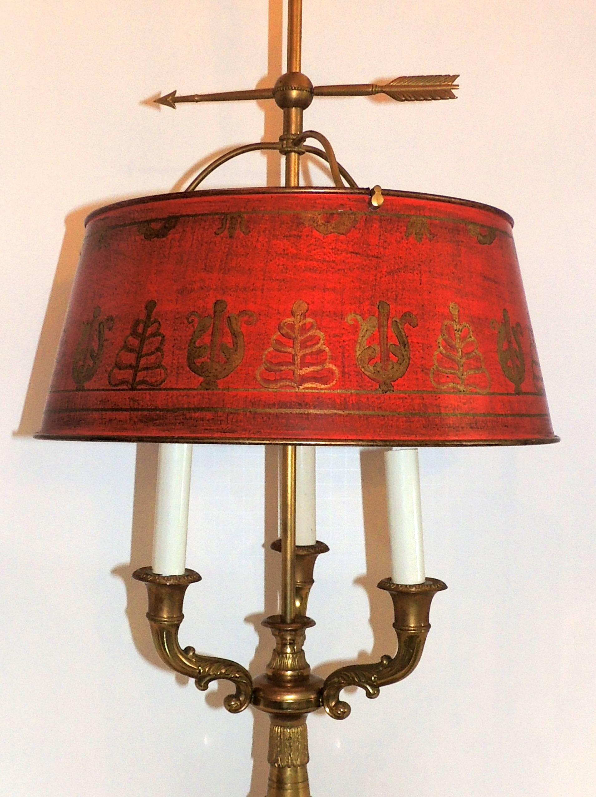 A wonderful French bronze neoclassical bouillotte lamp with three lights and decorated red tole shade in the Regency motif.