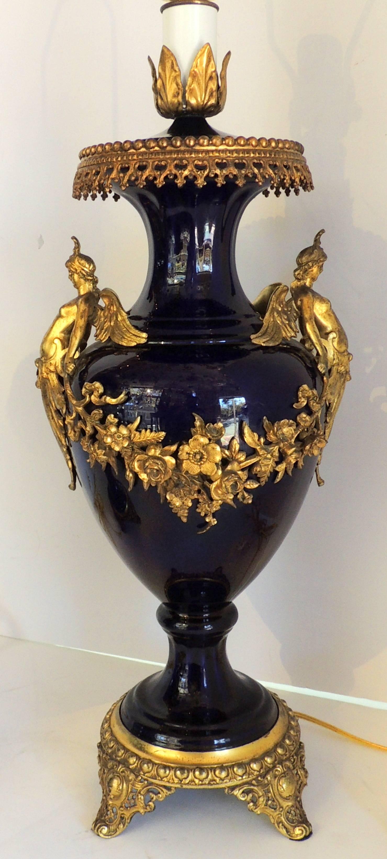 A wonderful pair of French doré bronze ormolu-mounted women figure and bouquet drapings of flowers Sevres cobalt blue porcelain urn form lamps.