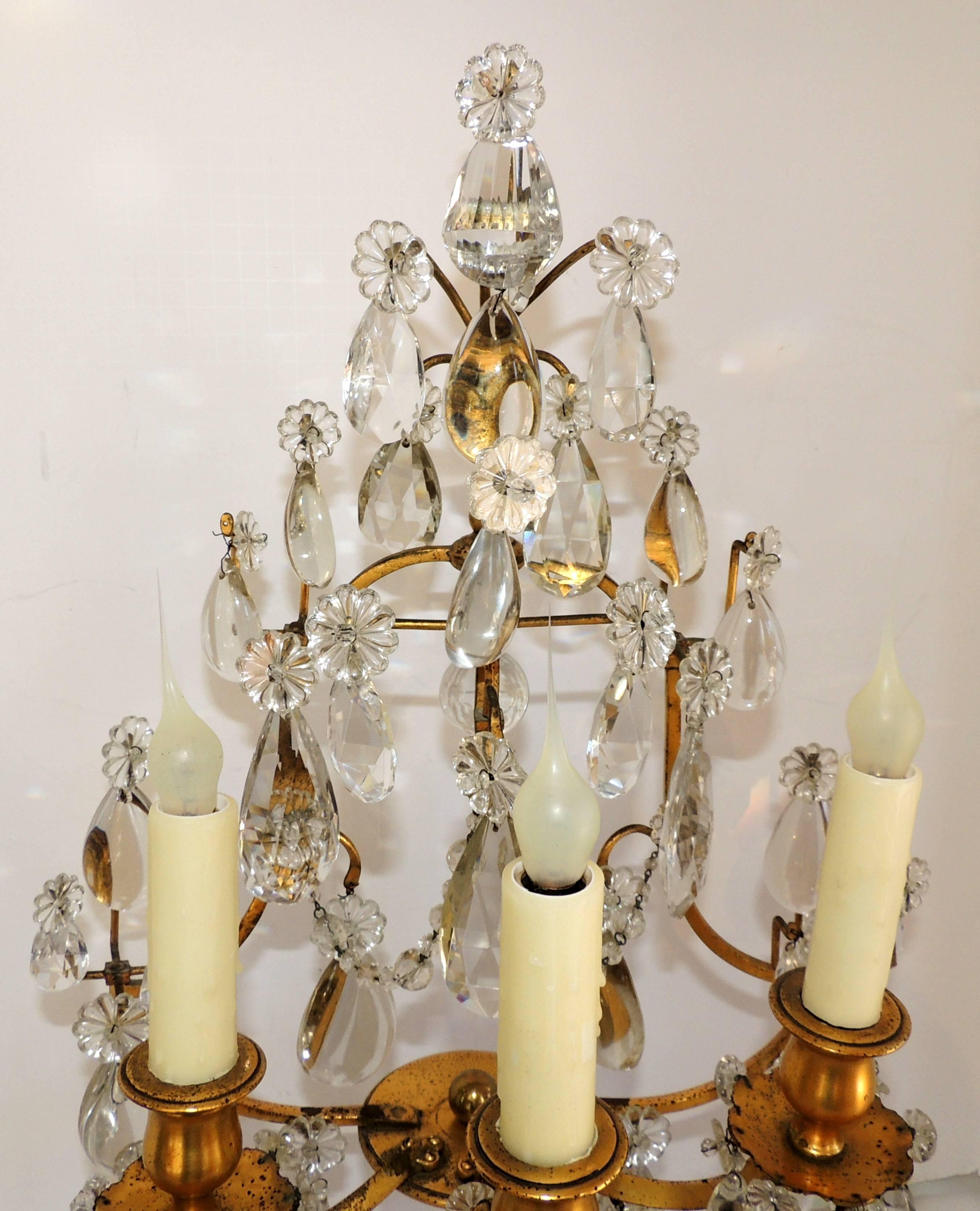A wonderful pair of French doré bronze and crystal girandoles / candelabras with three lights as lamps.