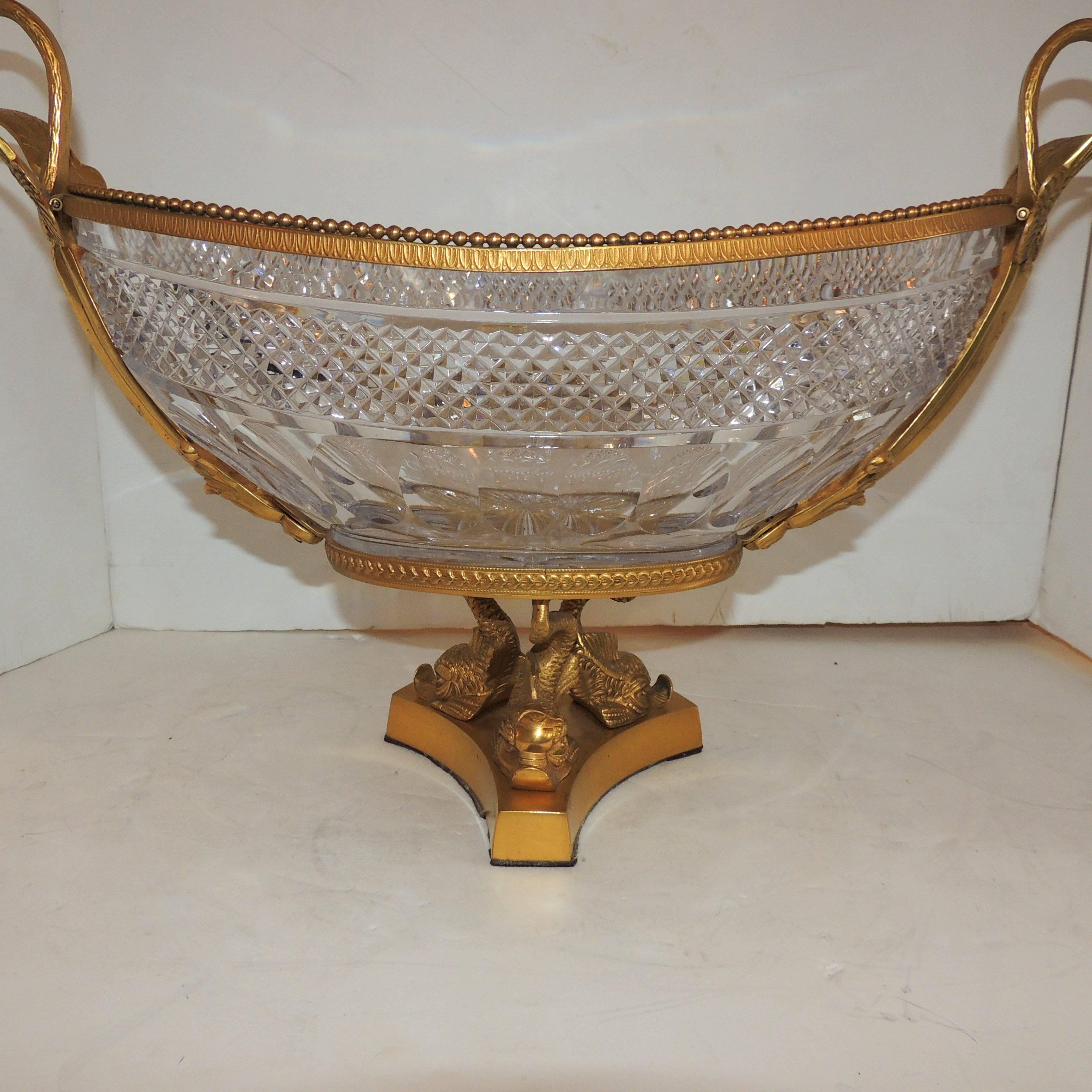 A wonderful French neoclassical dore´ bronze centerpiece with three dolphins on the pedestal and two lovely swans in flight on each side. The diamond cut crystal insert with star burst bottom add to the elegance of this impressive