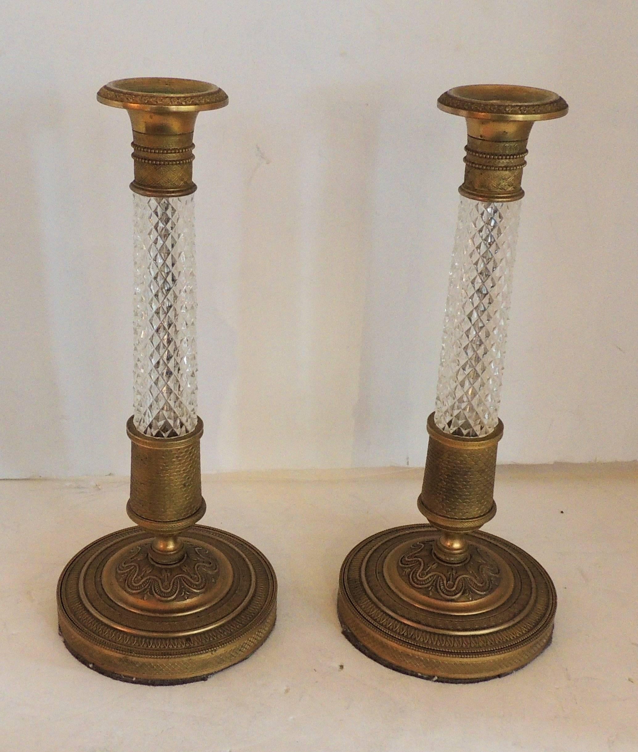 An elegant French Empire or neoclassical pair of doré bronze and cut crystal ormolu-mounted candlesticks.

Measures: 4.75W x 11 H.