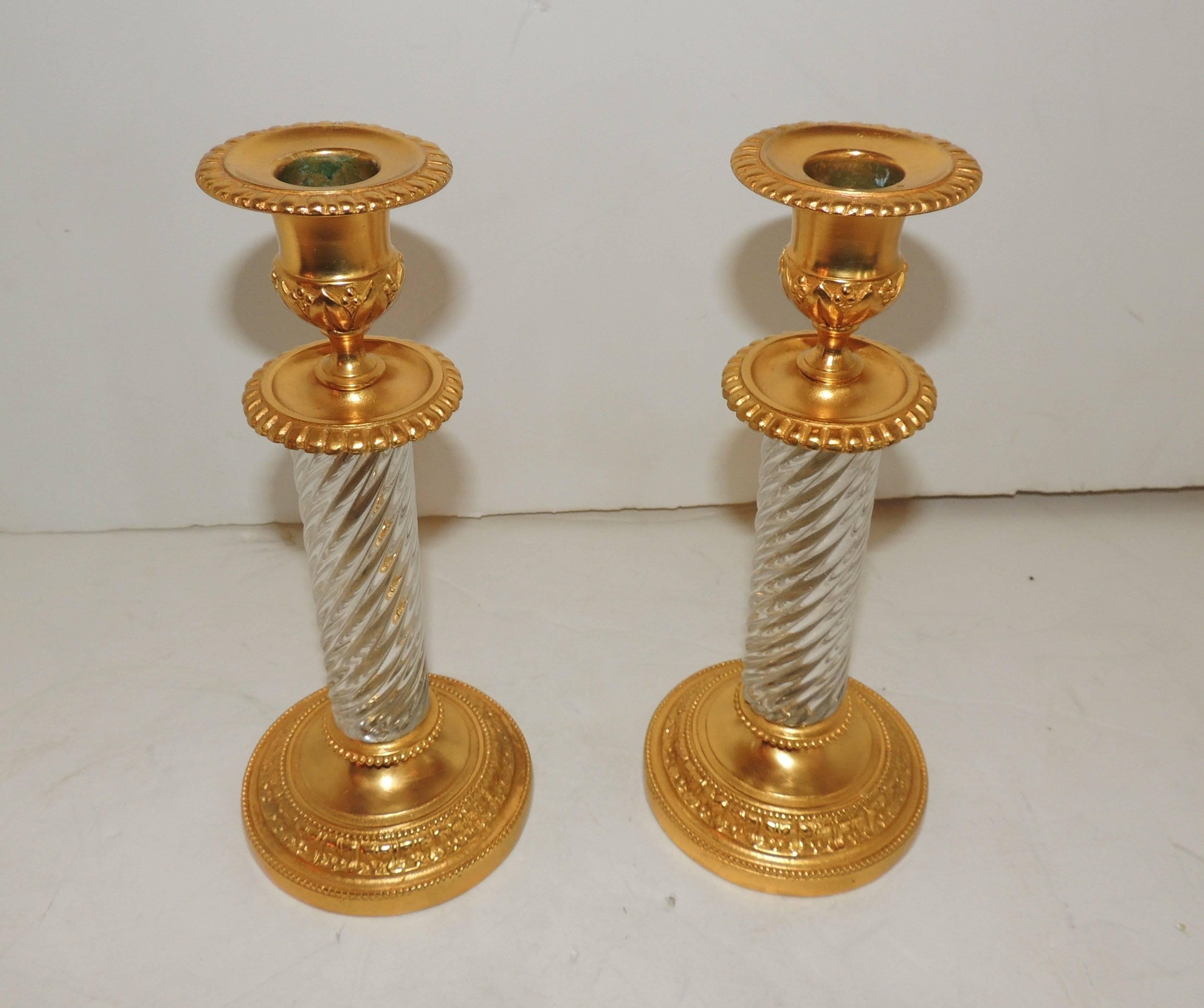 An elegant French Empire/neoclassical pair of doré bronze and cut crystal ormolu-mounted candlesticks.
In the manner of Baccarat.

Measures: 4.75" W x 11" H.