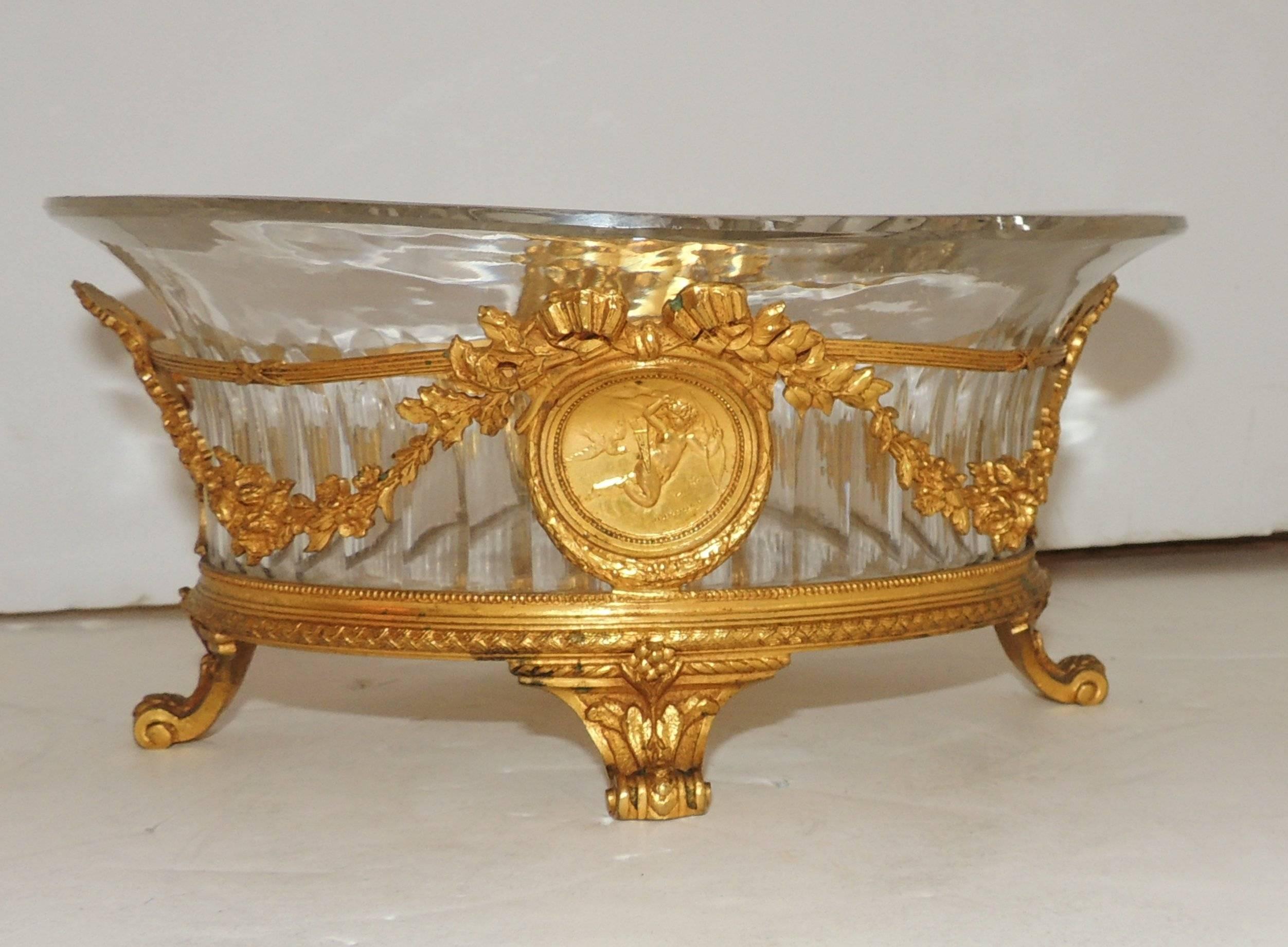 Wonderful French dore´ bronze bow and swag footed Cherub Plaques centerpiece with fluted oval crystal insert.
In the manner of Baccarat.

Measures: 8