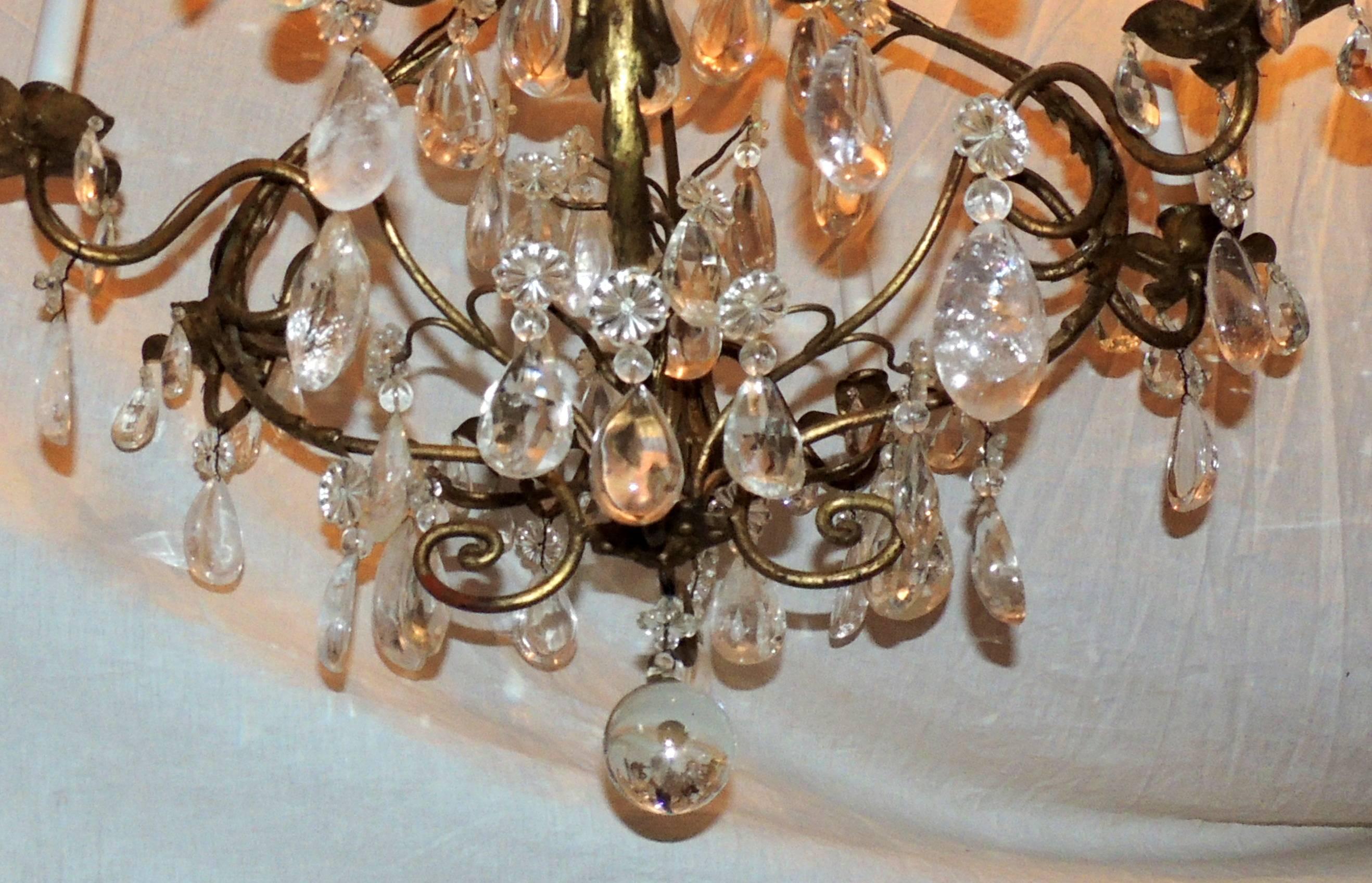 A wonderful French rock crystal Baguès style gold gilt eight-light, leaf bird cage Jansen motif chandelier light fixture.
