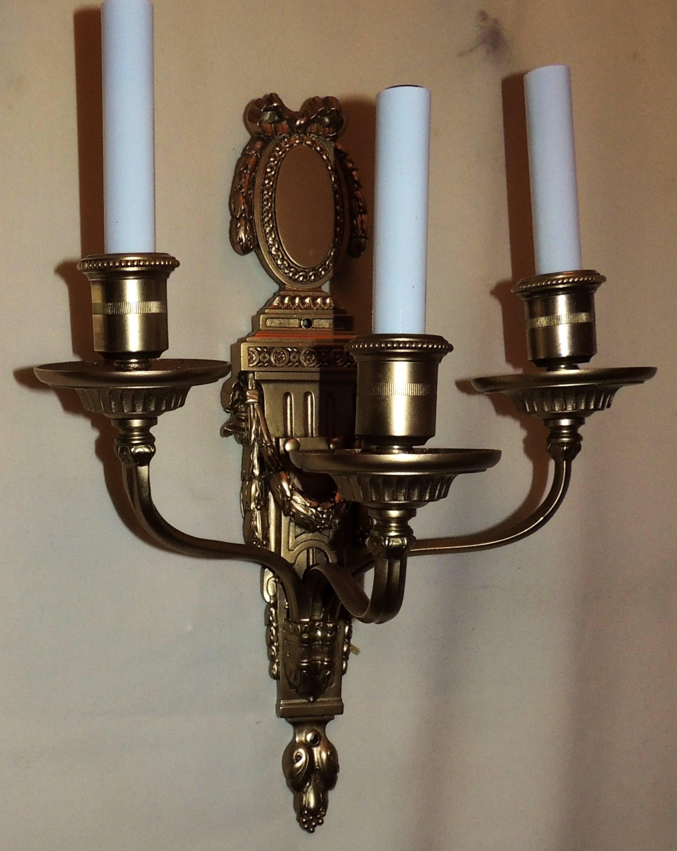 A fine pair of gilt bronze neoclassical bow top three-arm wall sconces, 
By E.F. Caldwell.