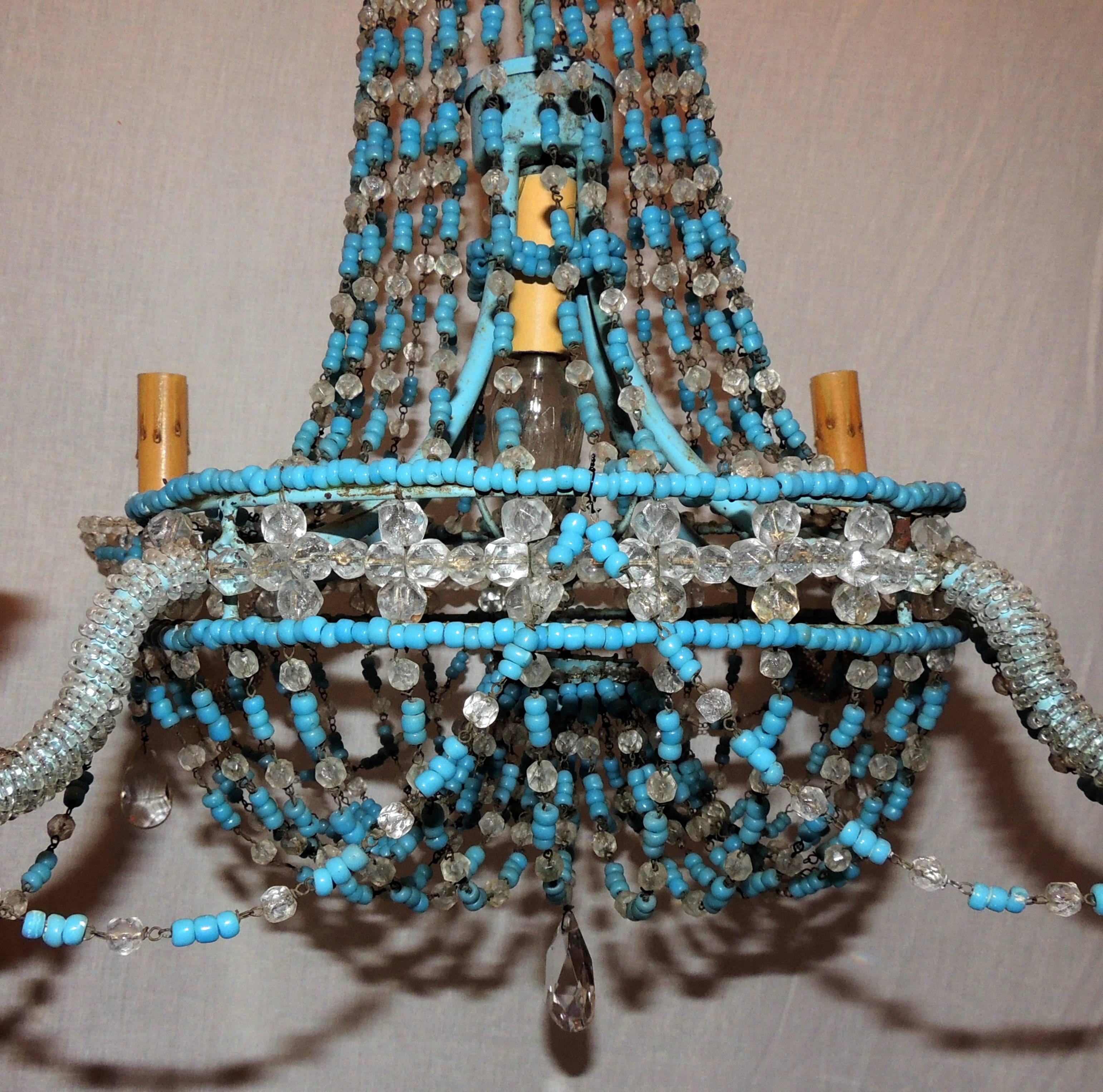 A wonderful pair of vintage turquoise beaded and crystal basket swag chandeliers made in Italy with 4 lights on the arms and one in the center of the fixture.